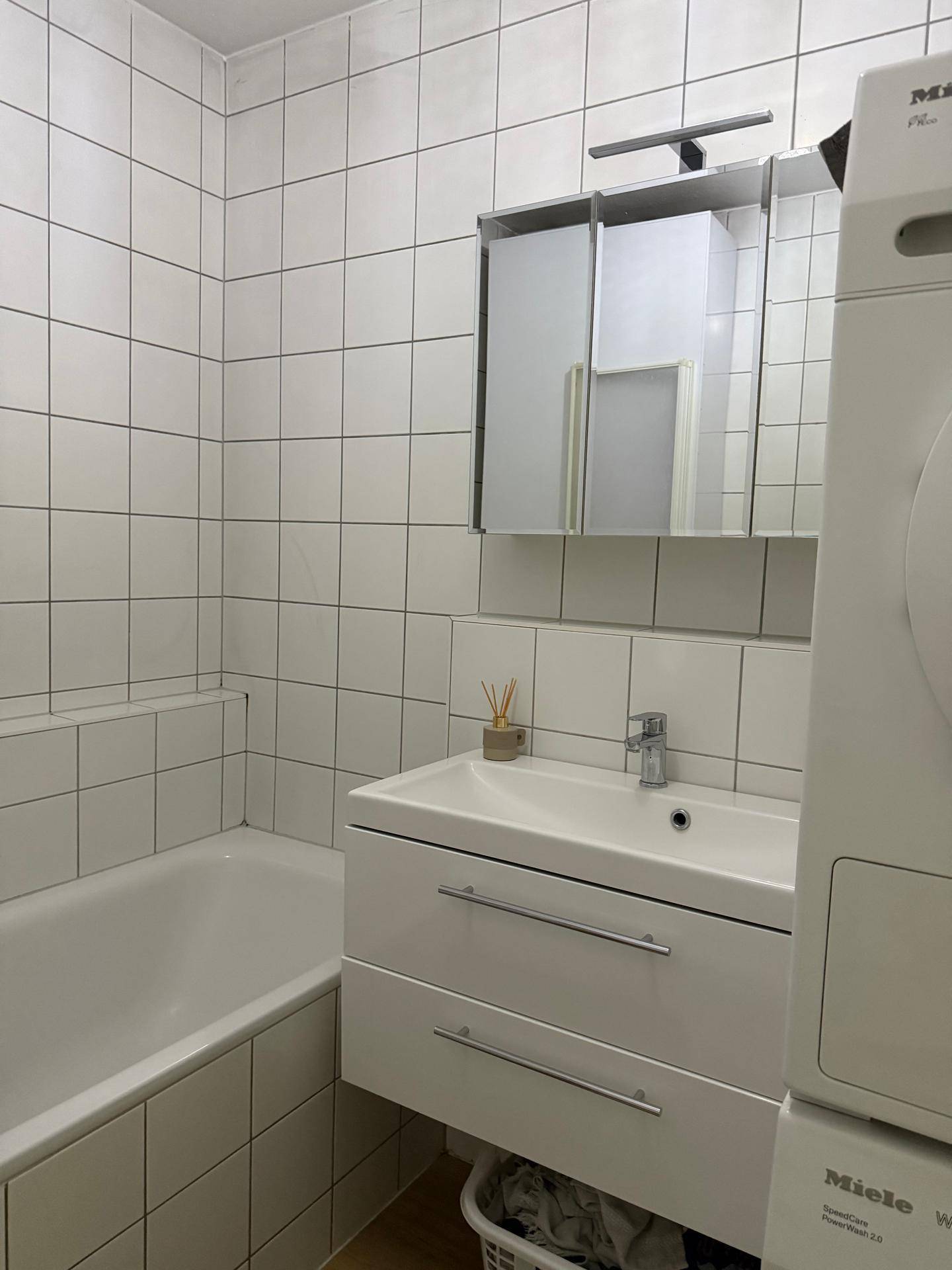 Modernes Badezimmer mit Waschbecken, Spiegelschrank und Badewanne.