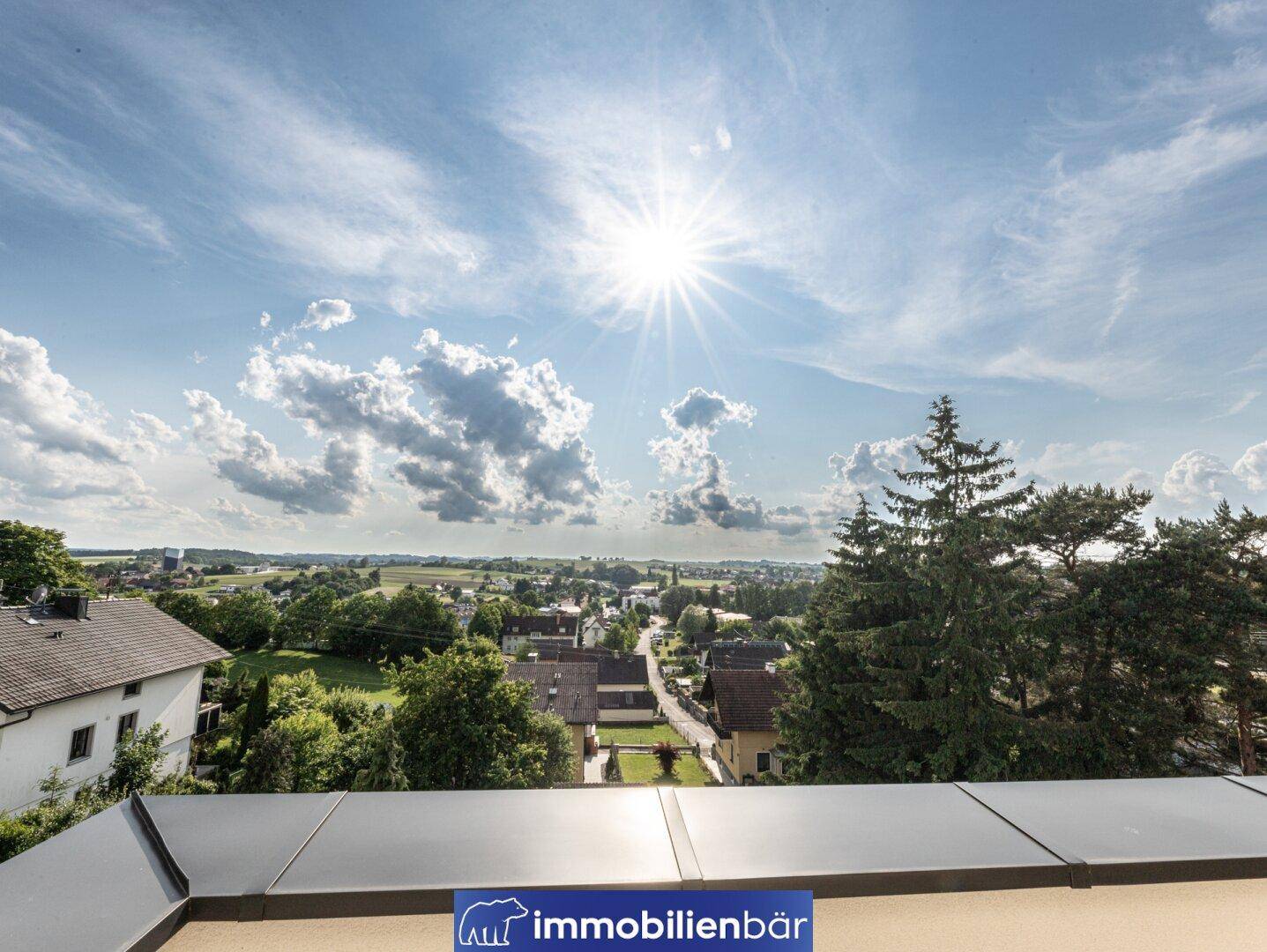 Panoramablick über die weite Landschaft und die umliegende Natur unter einem strahlend blauen Himmel.