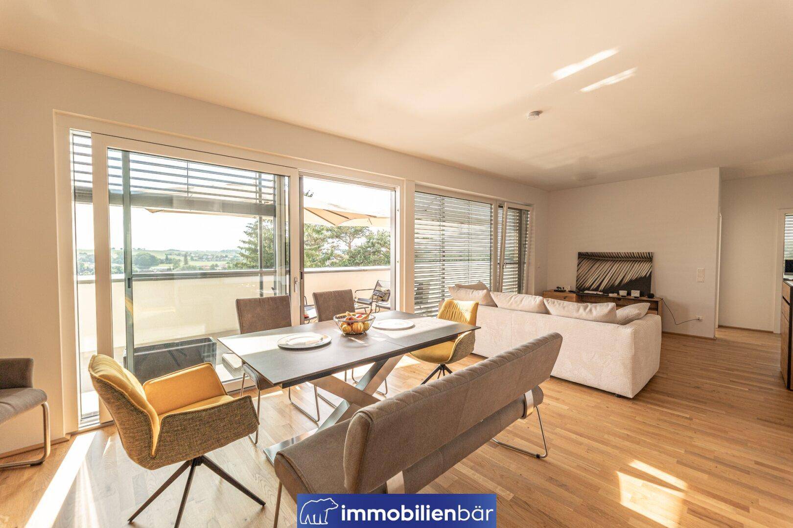 Heller Wohn- und Essbereich mit Holzboden und Zugang zur Terrasse, perfekt für gesellige Abende.