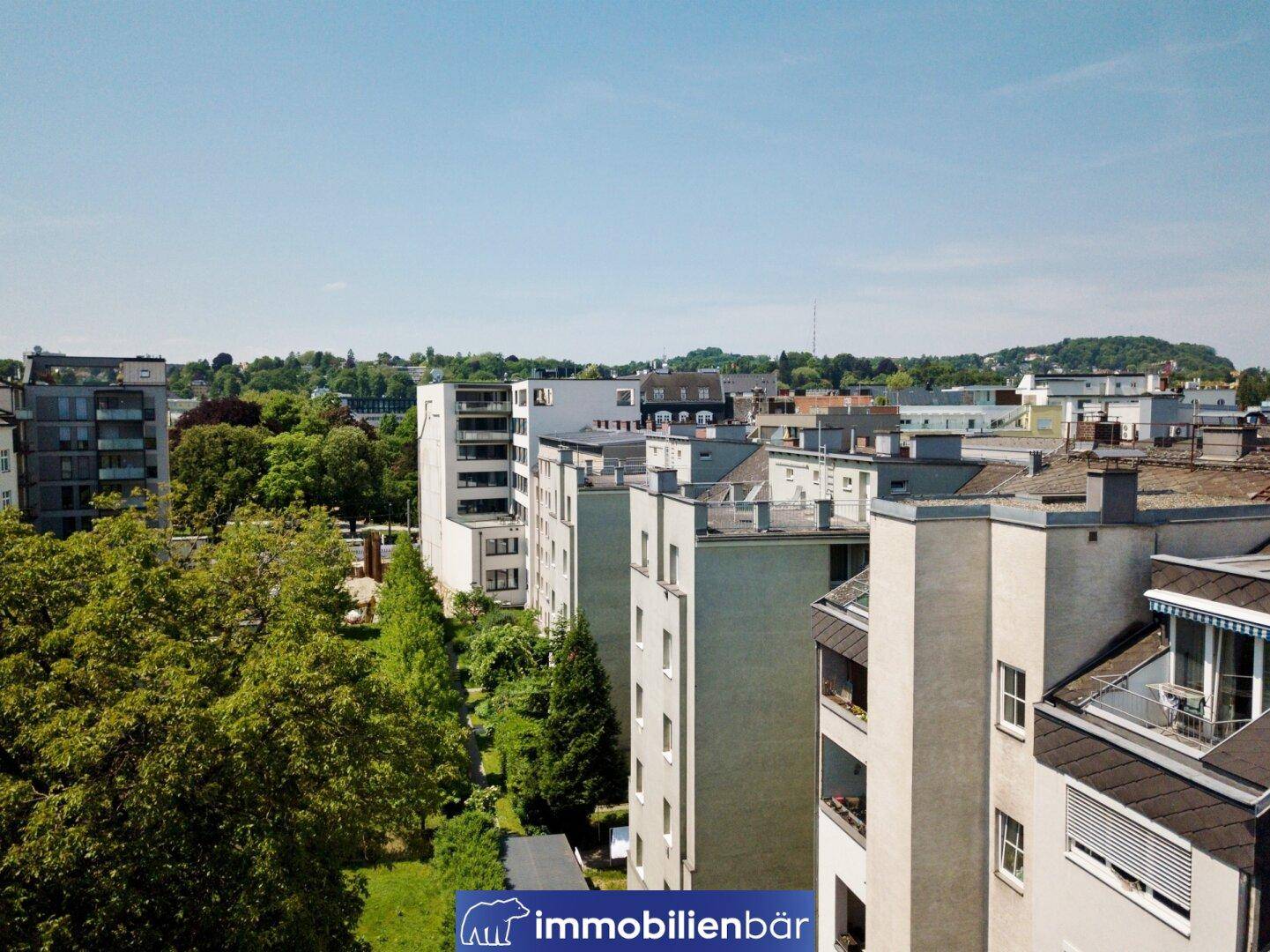 Weitläufiger Blick über die Stadt mit modernen Wohngebäuden und viel Grün.