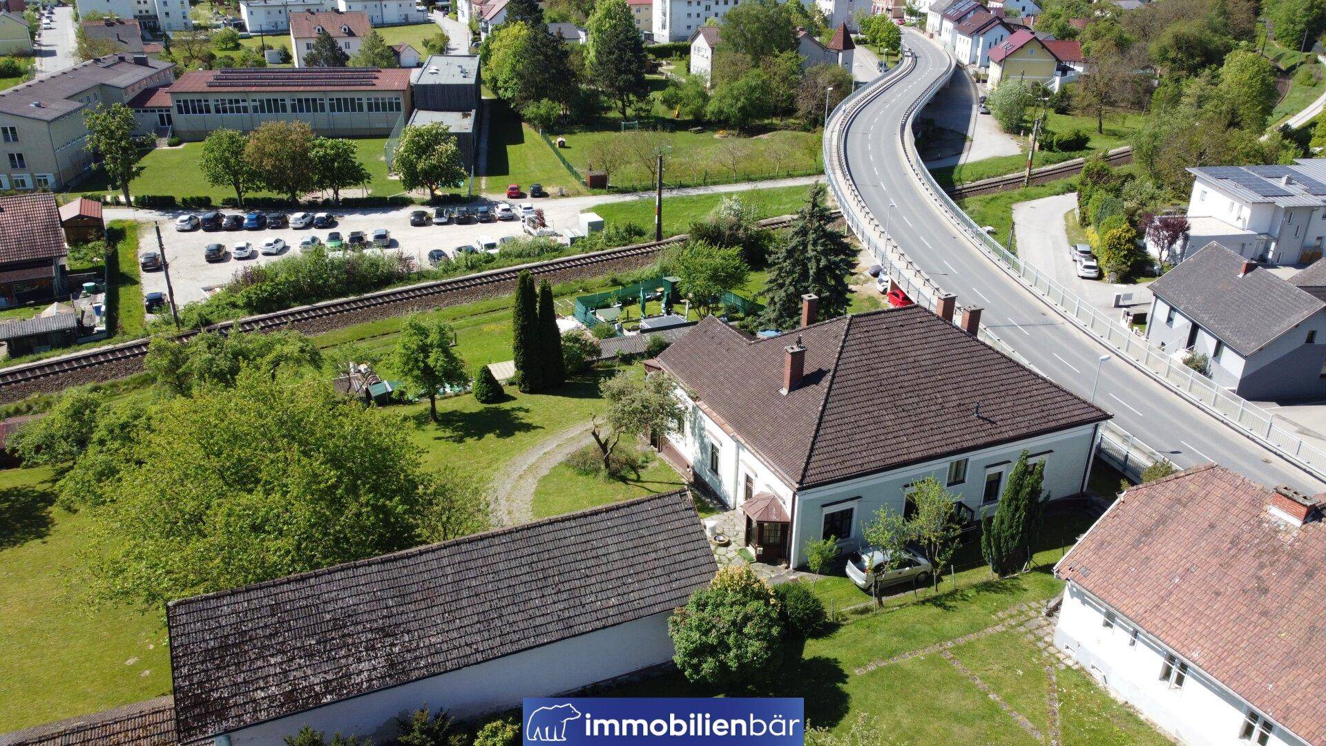 Luftaufnahme des Anwesens mit angrenzender Straße und Bahngleisen in ländlicher Lage.