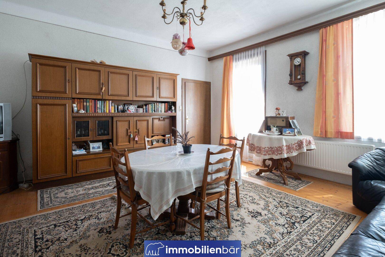 Geräumiger Essbereich mit großem Holztisch, Teppich und traditionellen Möbeln.
