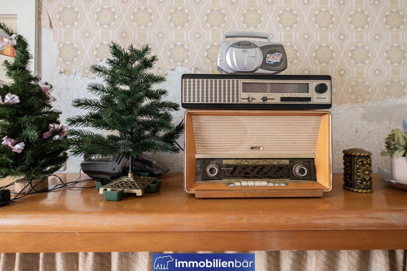 Detailaufnahme von Vintage-Radios und Weihnachtsdekoration auf einer Holzkommode.