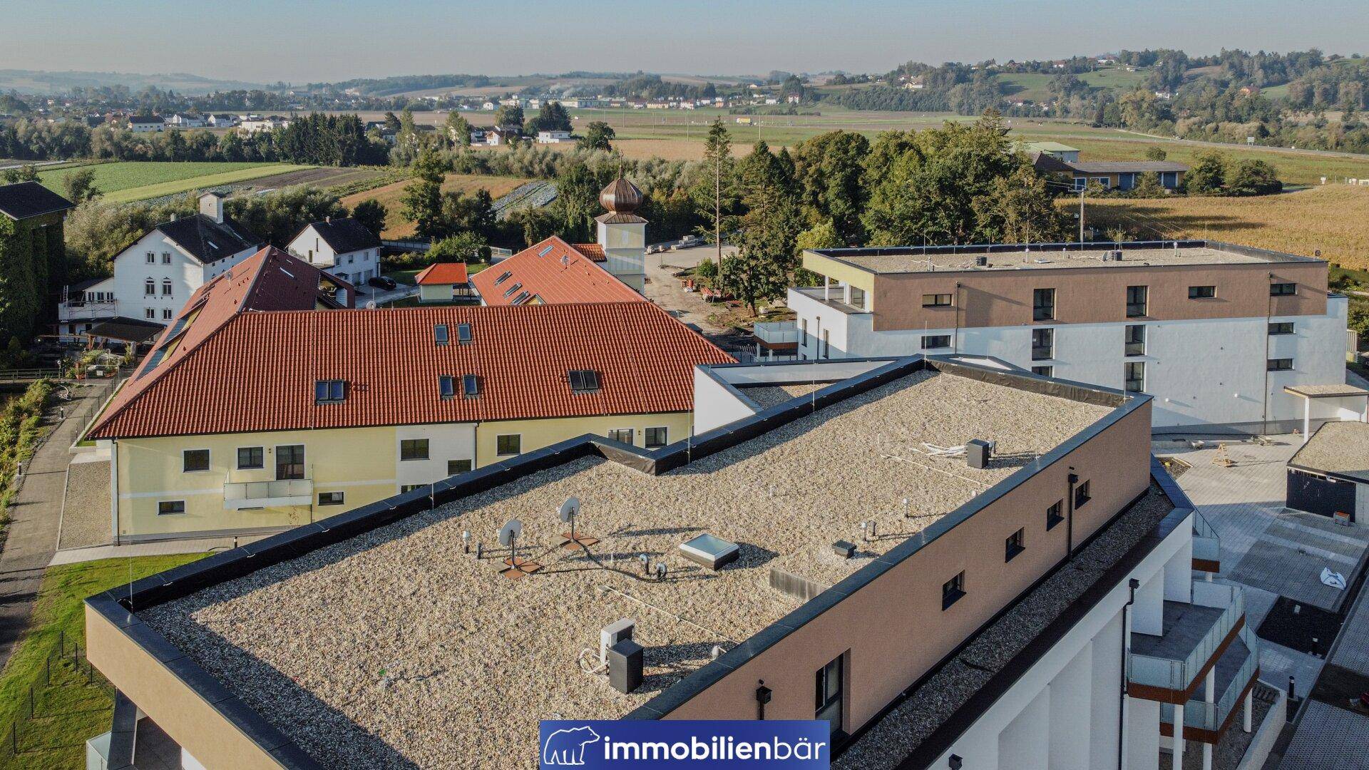 Luftaufnahme eines modernen Wohngebäudes mit Flachdach und Satellitenanlagen.