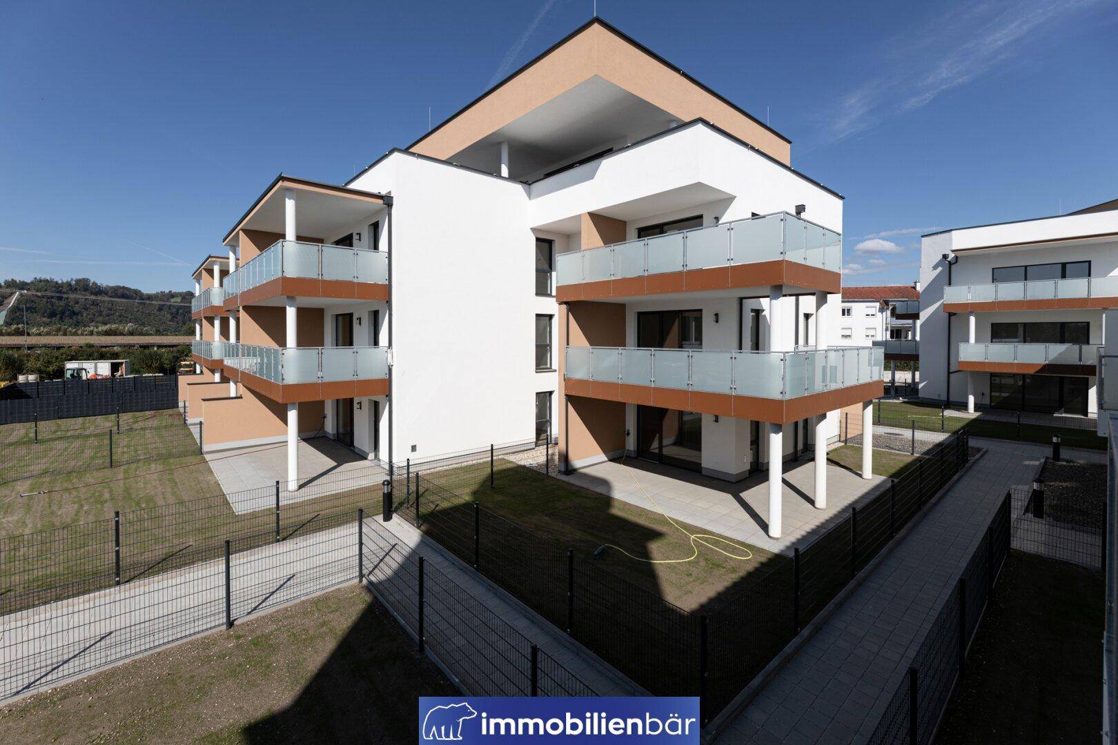 Modernes Wohngebäude mit Balkonen und gepflegten Außenanlagen.
