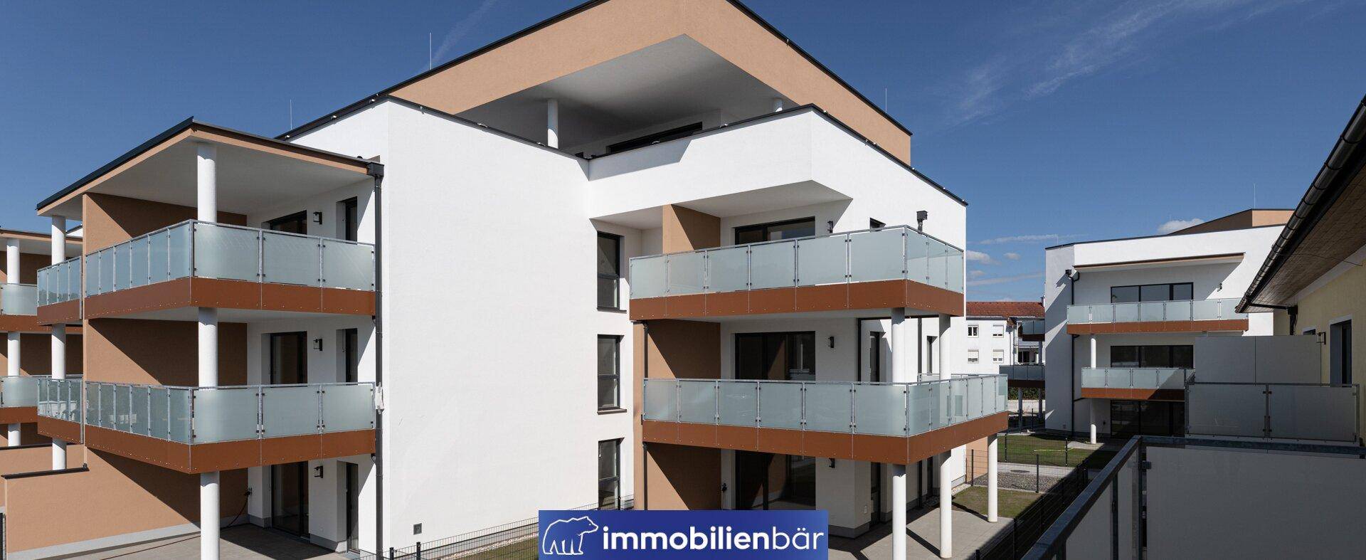 Ansicht eines modernen Wohngebäudes mit mehreren Balkonen und klarem Himmel.