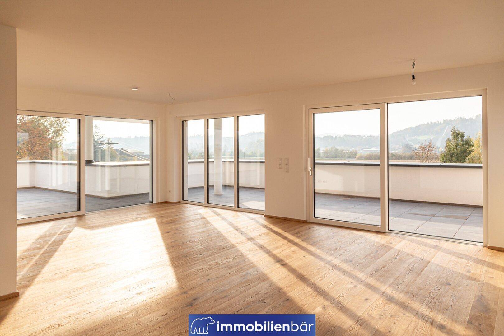 Helles, geräumiges Zimmer mit Holzboden und großen Schiebetüren zur Terrasse mit Weitblick.