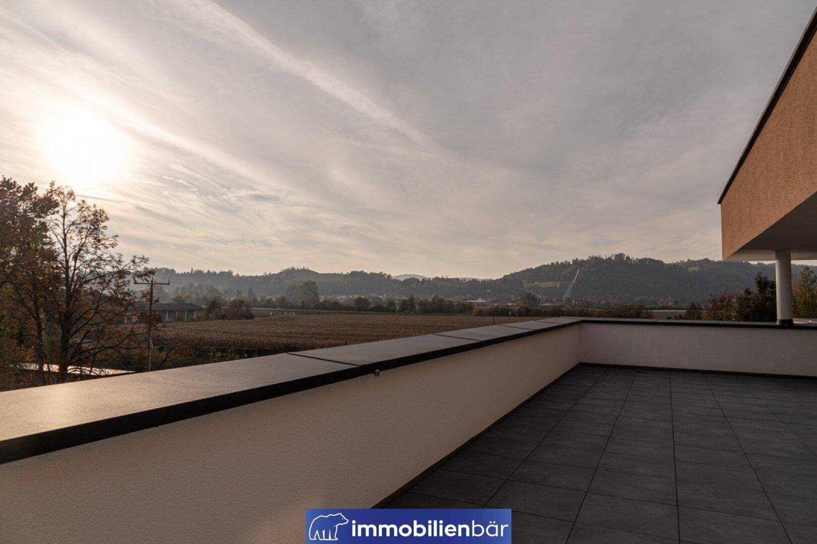 Weitläufige Terrasse mit Fliesenboden und Panoramablick auf die ländliche Umgebung.