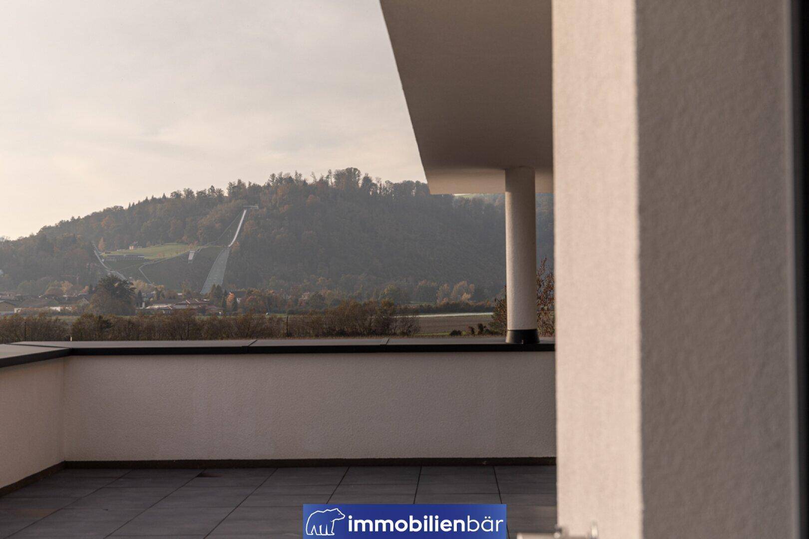 Geräumige Außenterrasse mit Blick auf die hügelige Landschaft und die umliegende Natur.