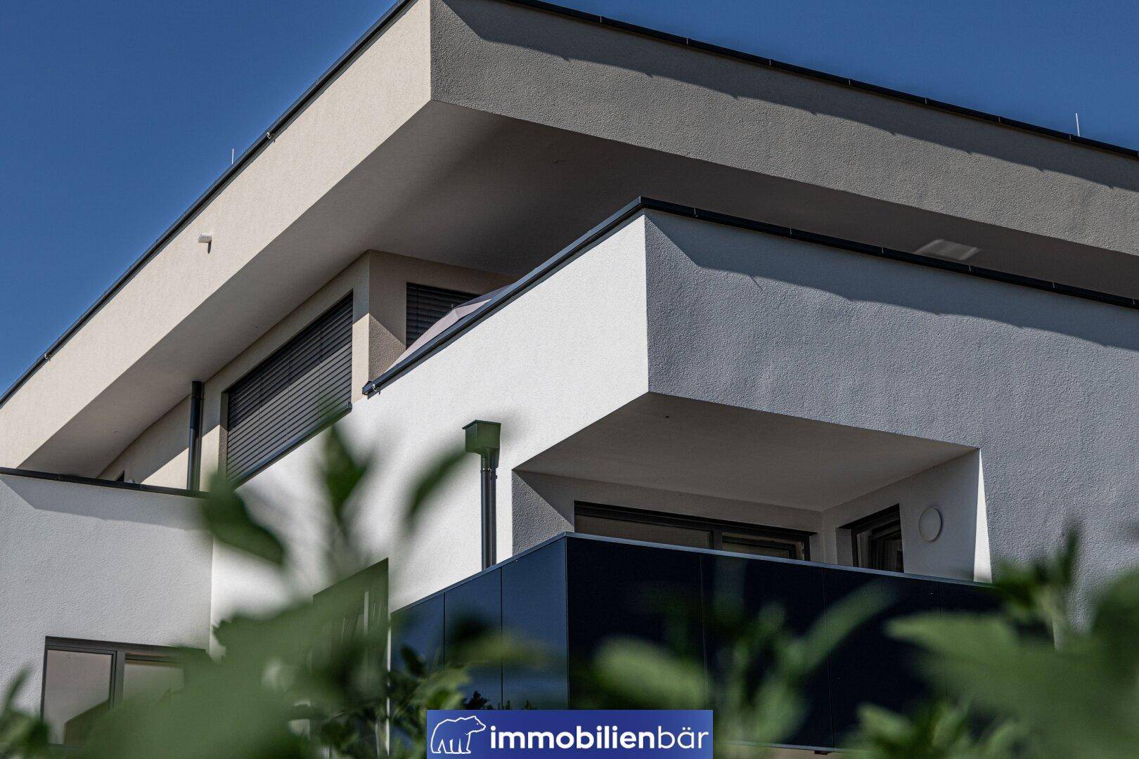 Detailansicht eines modernen Balkons mit dunkler Brüstung und minimalistischer Architektur.