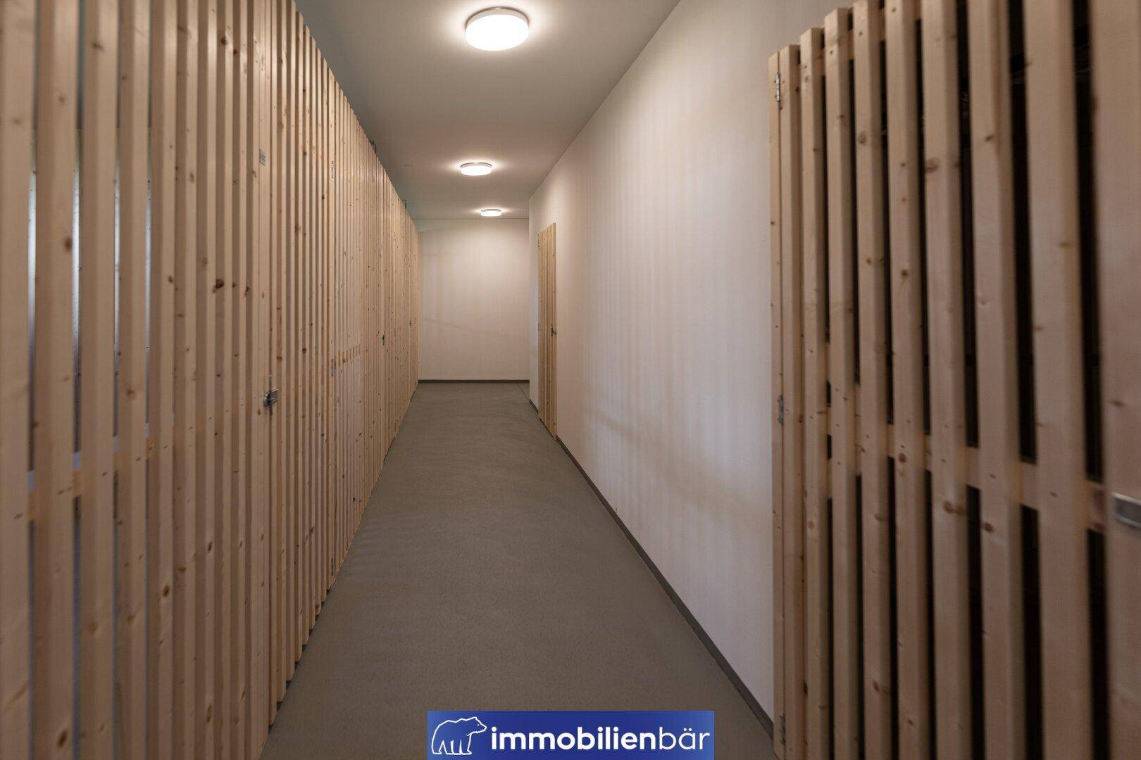 Moderner Flur mit Holzwänden und indirekter Beleuchtung, schafft eine warme und einladende Atmosphäre.