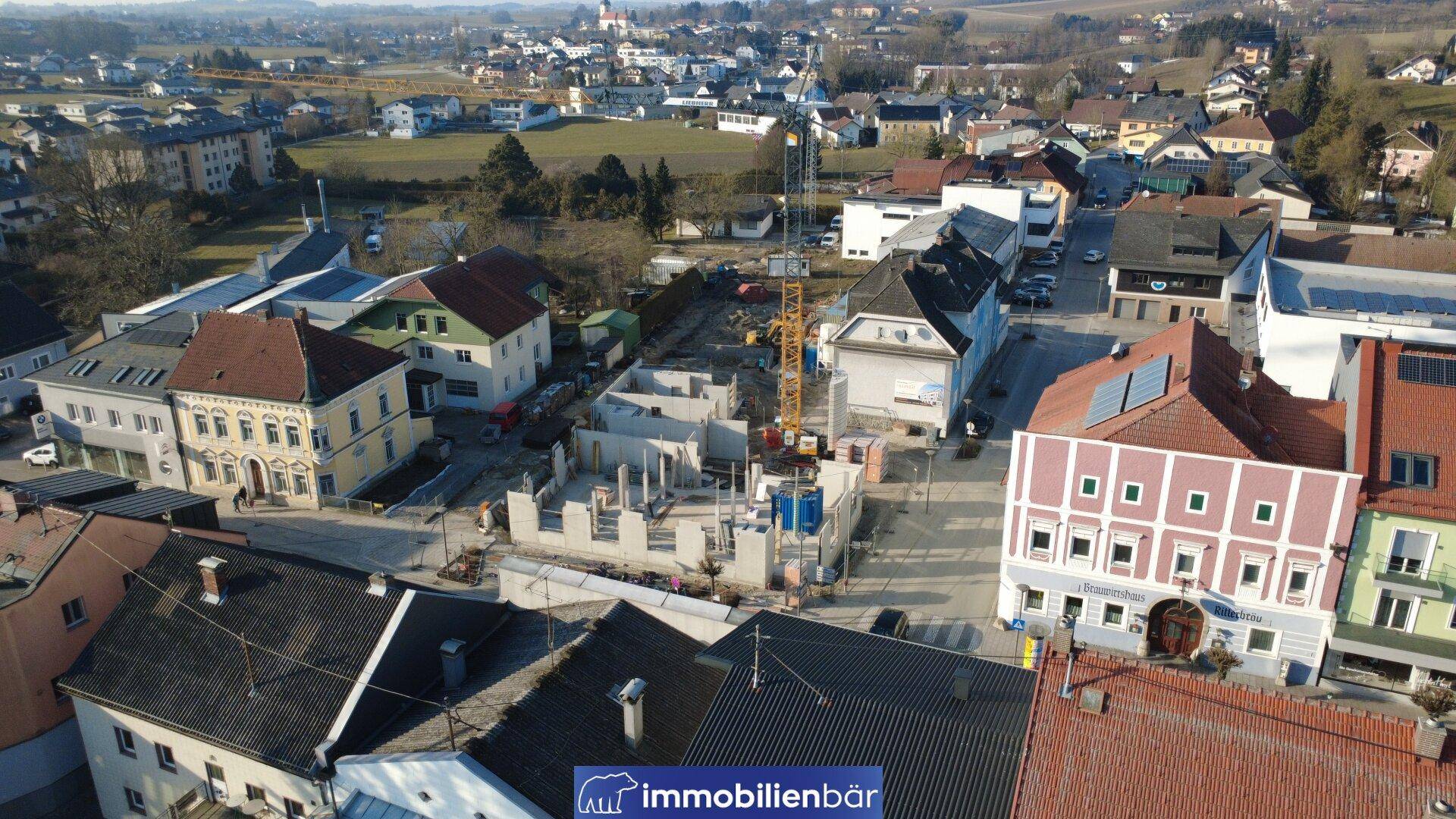 Luftaufnahme einer Baustelle in einer ländlichen Umgebung mit umliegenden Gebäuden.