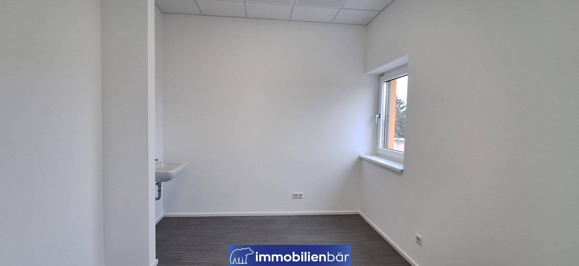 Heller Raum mit einem Fenster und einem Waschbecken, ideal als kleines Büro oder praktischer Abstellraum.