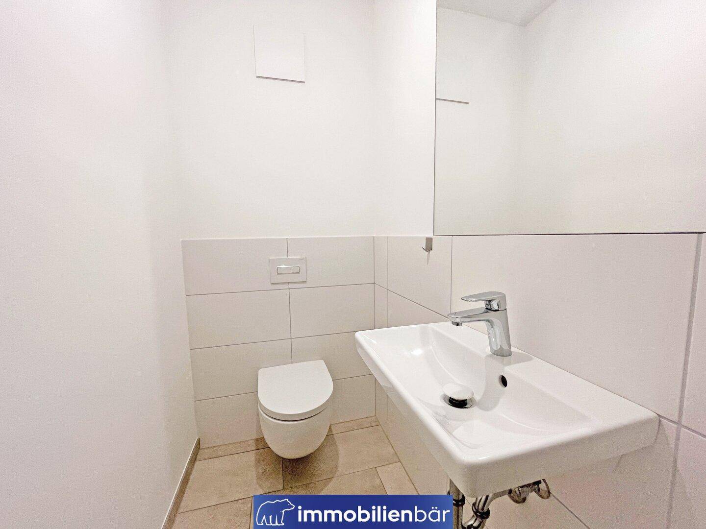 Modernes Gäste-WC mit wandhängender Toilette, Einzelwaschbecken und Spiegel.