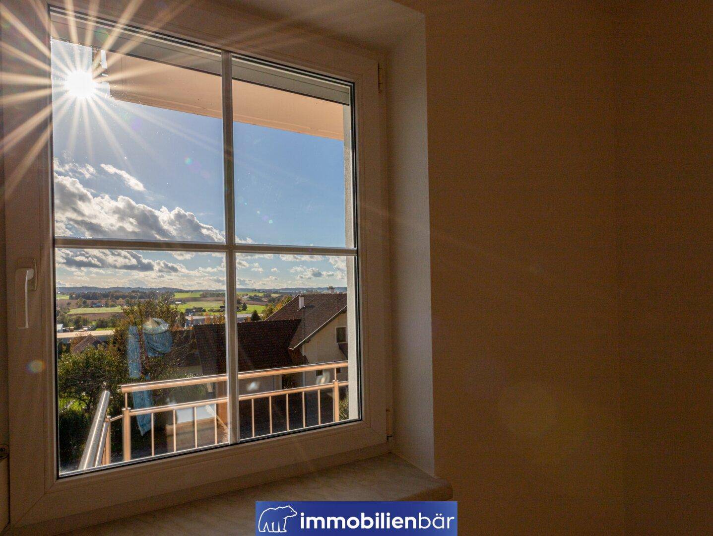 Heller Innenraum mit Fensterblick auf die weite Landschaft und sonnige Umgebung.