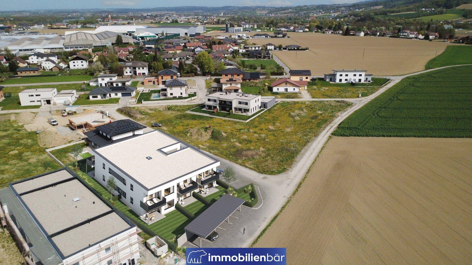Luftaufnahme der Wohnanlage mit Blick auf die umliegende Landschaft und nahegelegene städtische Bebauung.