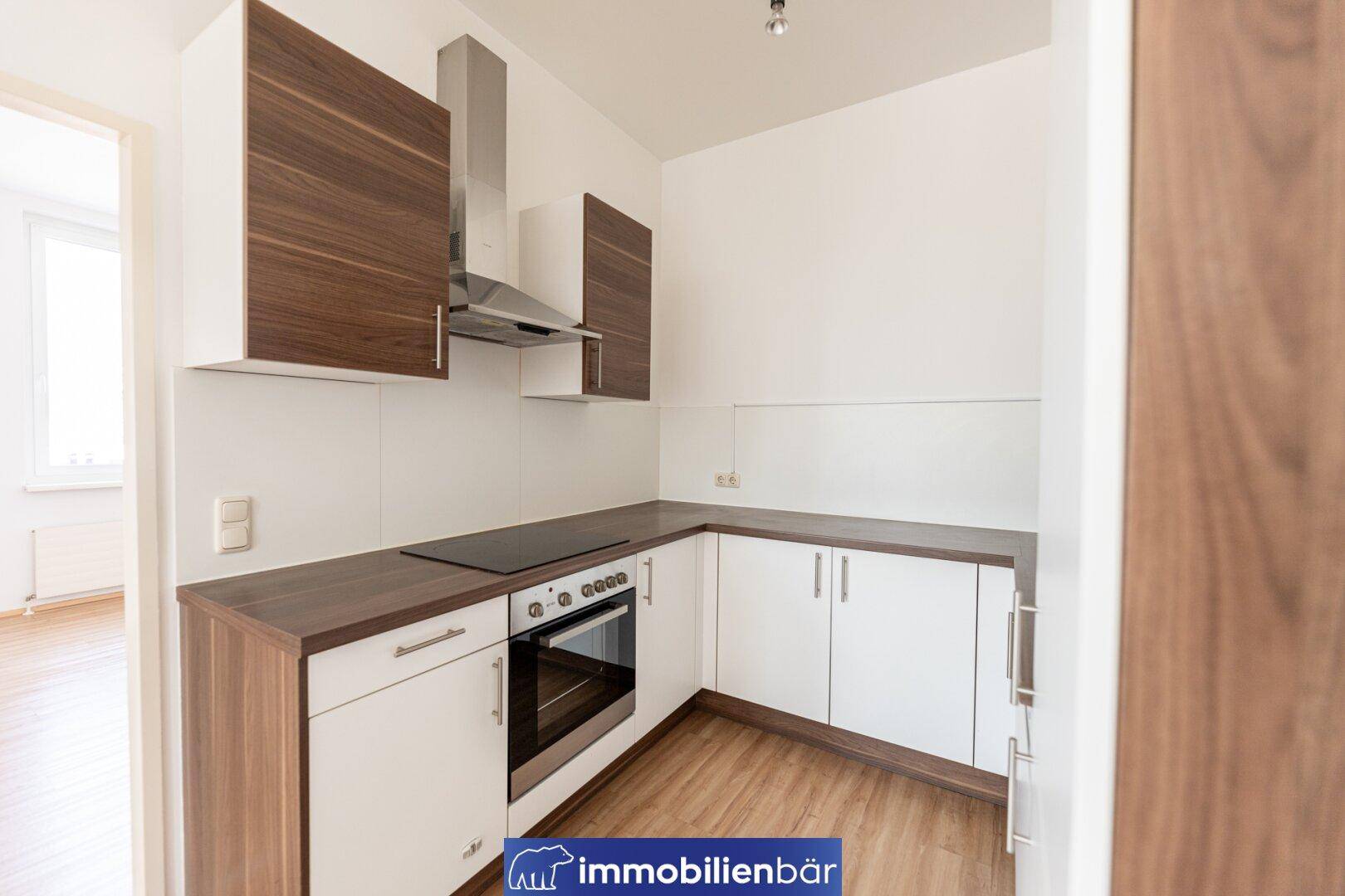 Funktionale Küchenzeile mit Backofen, Induktionskochfeld und Dunstabzugshaube, in modernem Design.