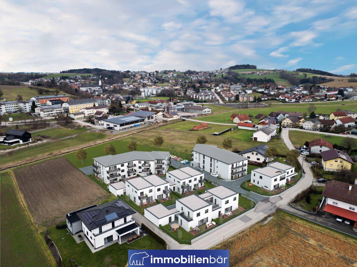 Luftaufnahme einer modernen Wohnsiedlung in ländlicher Umgebung mit Blick auf die umliegende Landschaft.