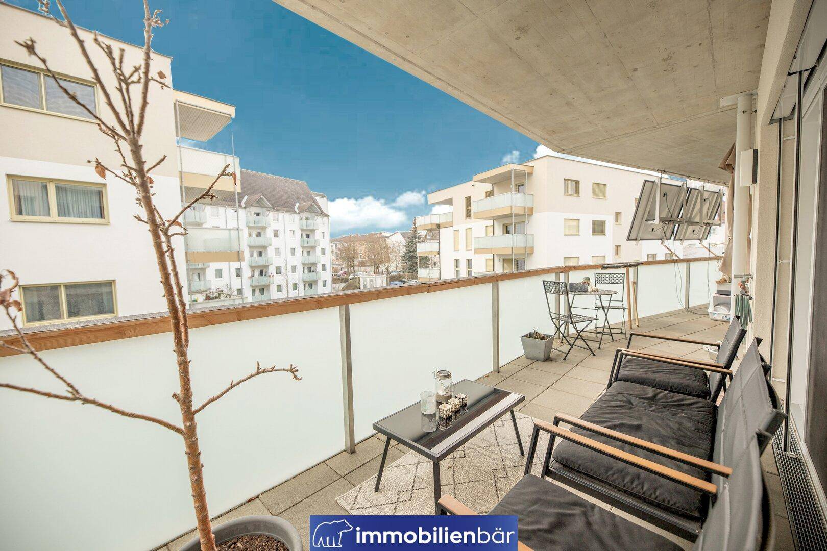 Geräumiger Balkon mit Sitzgelegenheiten und Blick auf die umliegenden Gebäude.