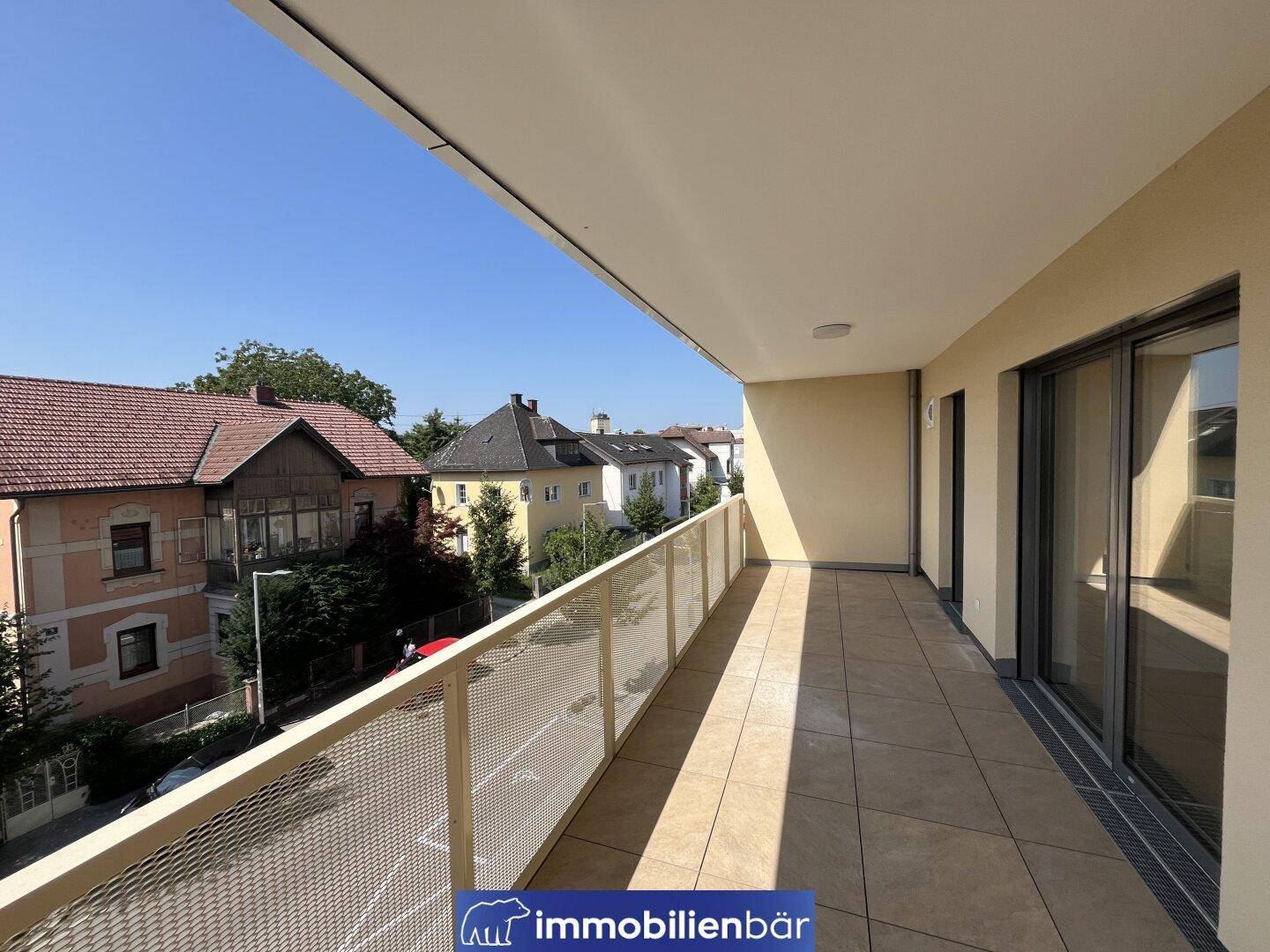Geräumiger Balkon mit Fliesenboden und Blick auf die umliegende Wohngegend.