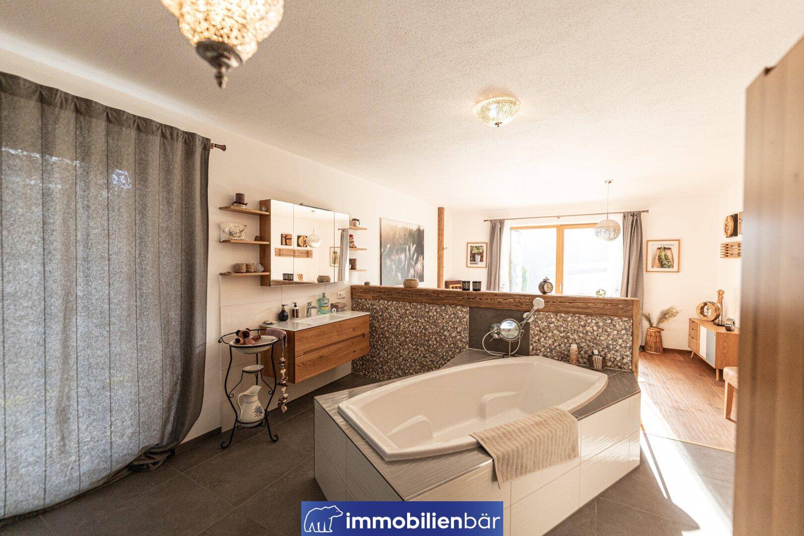 Geräumiges Badezimmer mit großer Badewanne, Doppelwaschbecken und modernen Fliesen.