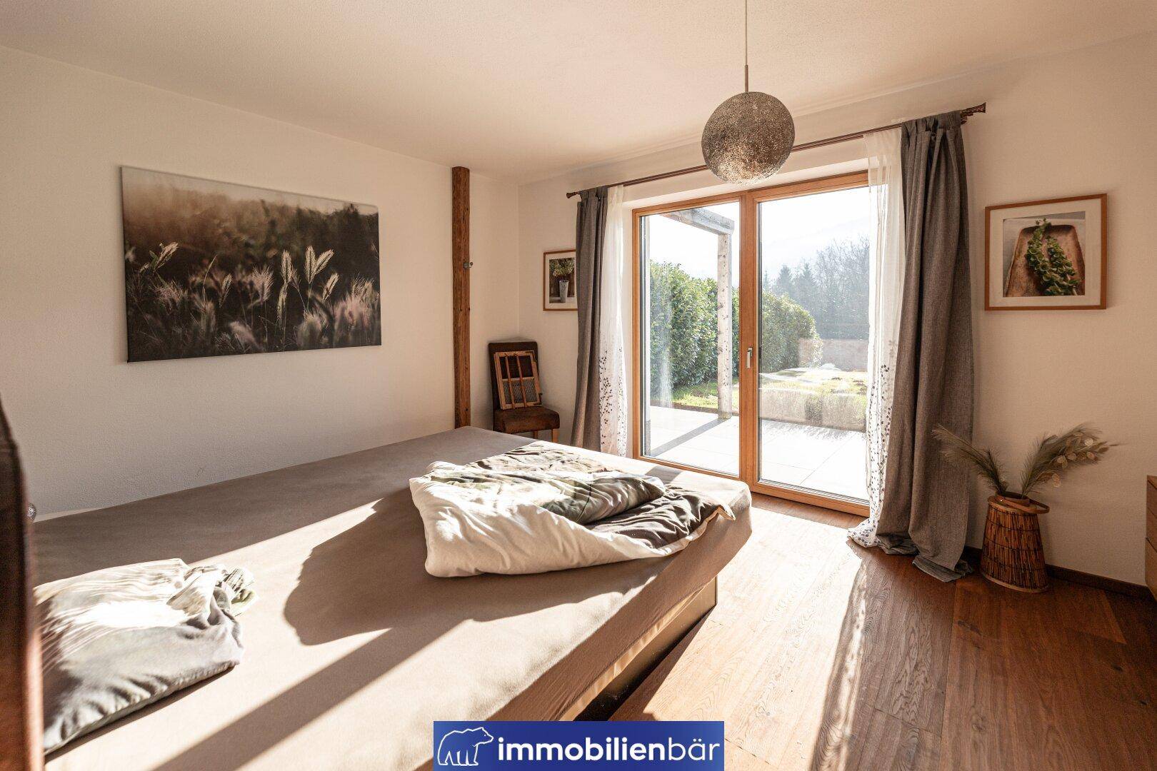 Helles Schlafzimmer mit Holzboden und direktem Zugang zum Garten oder zur Terrasse.