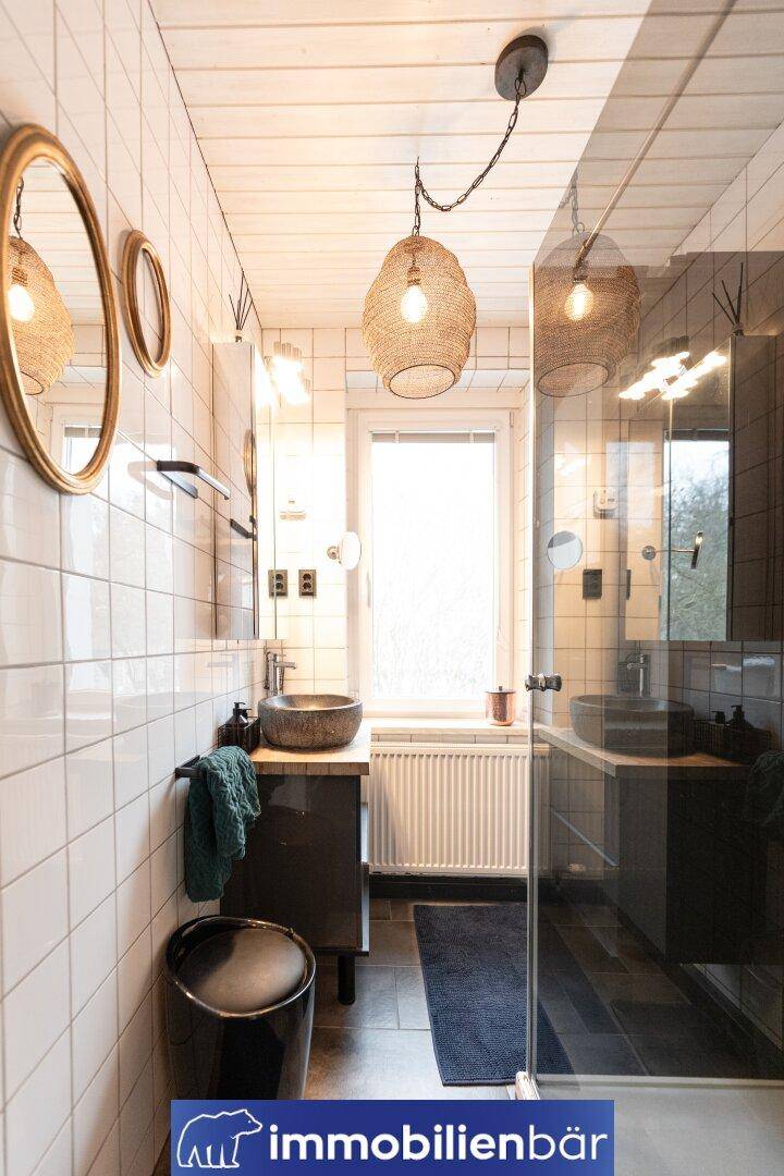 Modernes Badezimmer mit weißen Fliesen, Aufsatzwaschbecken und einer begehbaren Dusche.