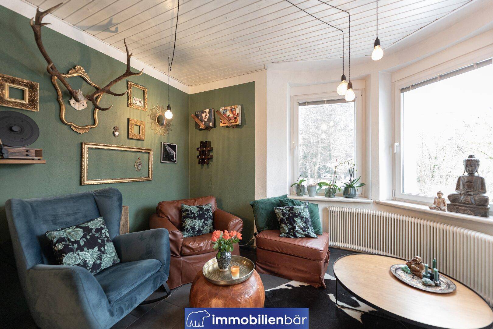 Gemütliches Wohnzimmer mit grünen Wänden, Holzbalkendecke und eklektischer Dekoration.
