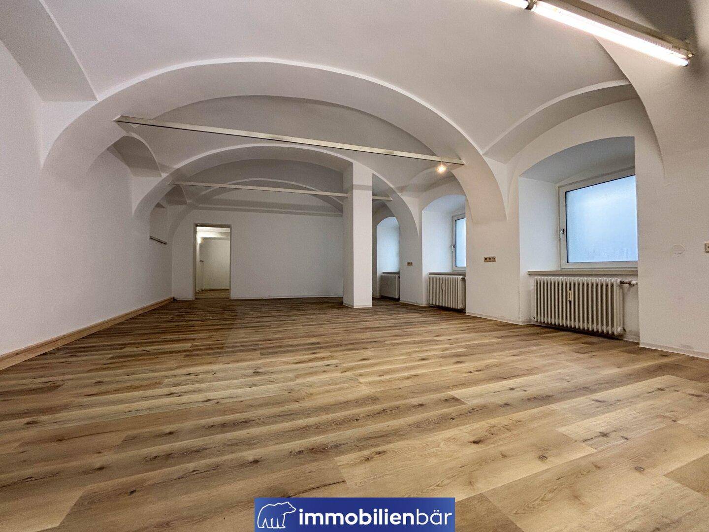 Geräumiger, heller Innenraum mit beeindruckenden Gewölbedecken und neu verlegtem Laminatboden, ideal für vielfältige Nutzung.