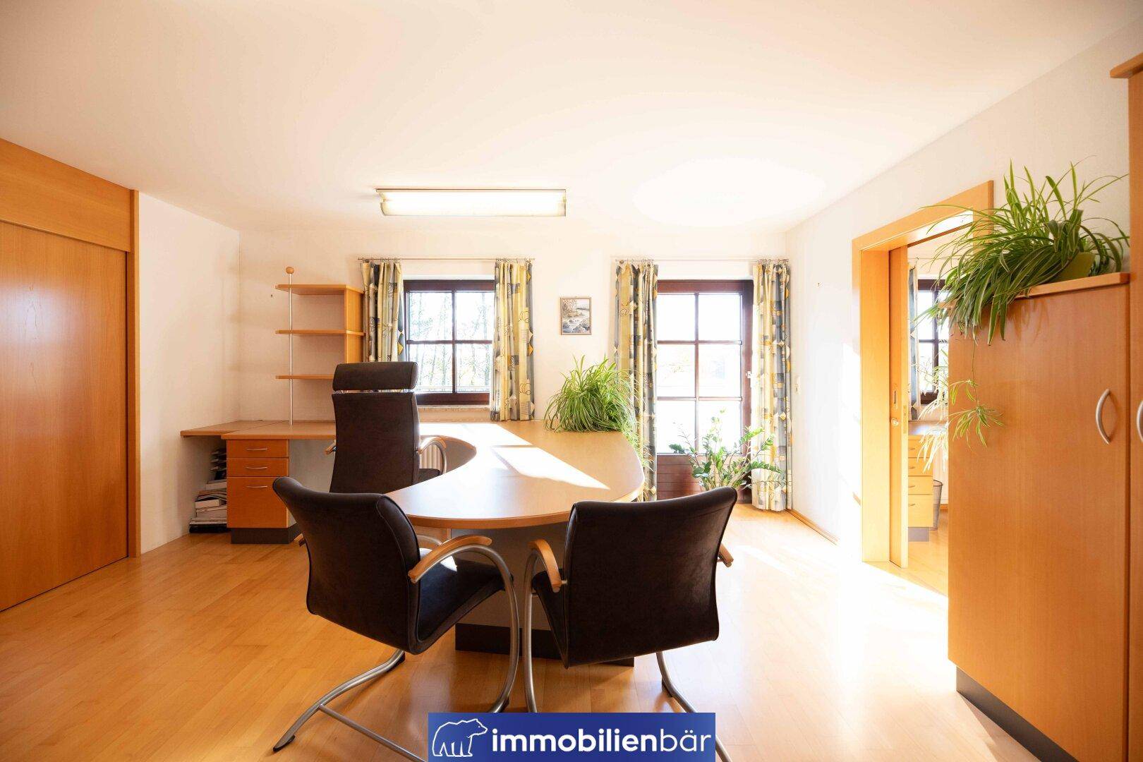 Geräumiges Büro mit viel Tageslicht und praktischen Holzmöbeln, ideal für Home-Office.