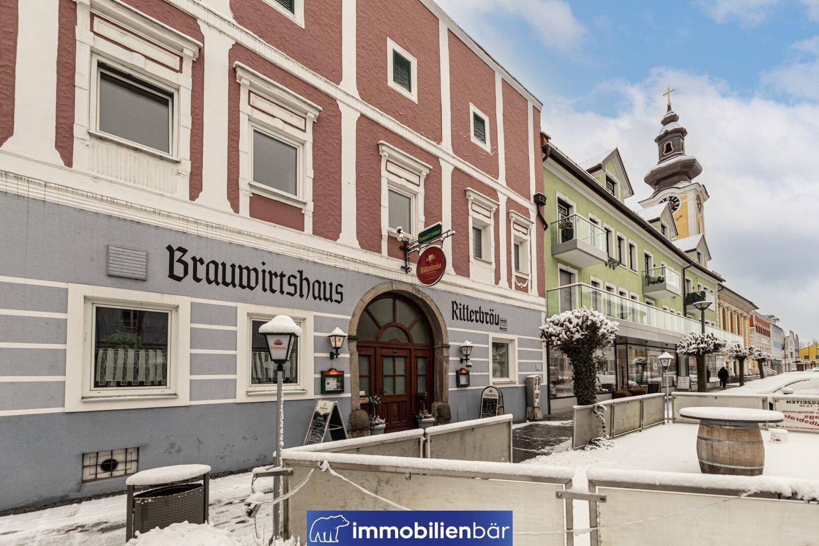 Historisches Gebäude mit traditioneller Fassade und verschneiter Straße im Winter.