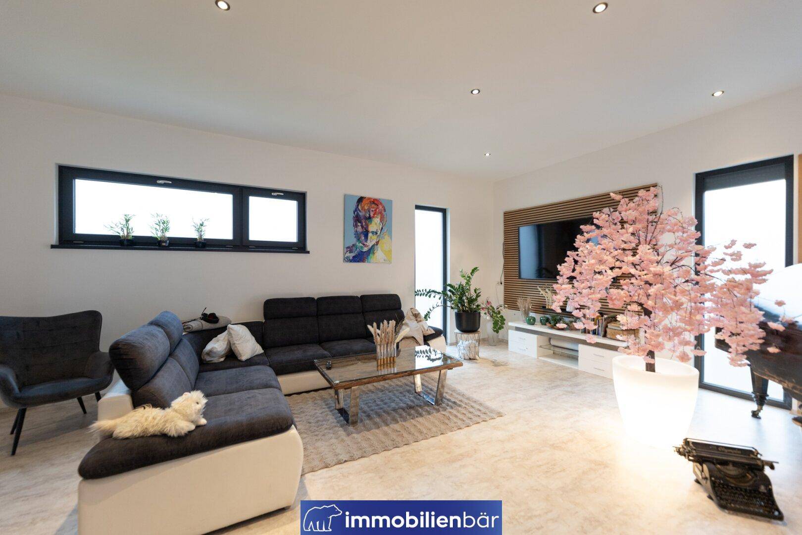Geräumiges Wohnzimmer mit großer Couch, Couchtisch und dekorativen Elementen.