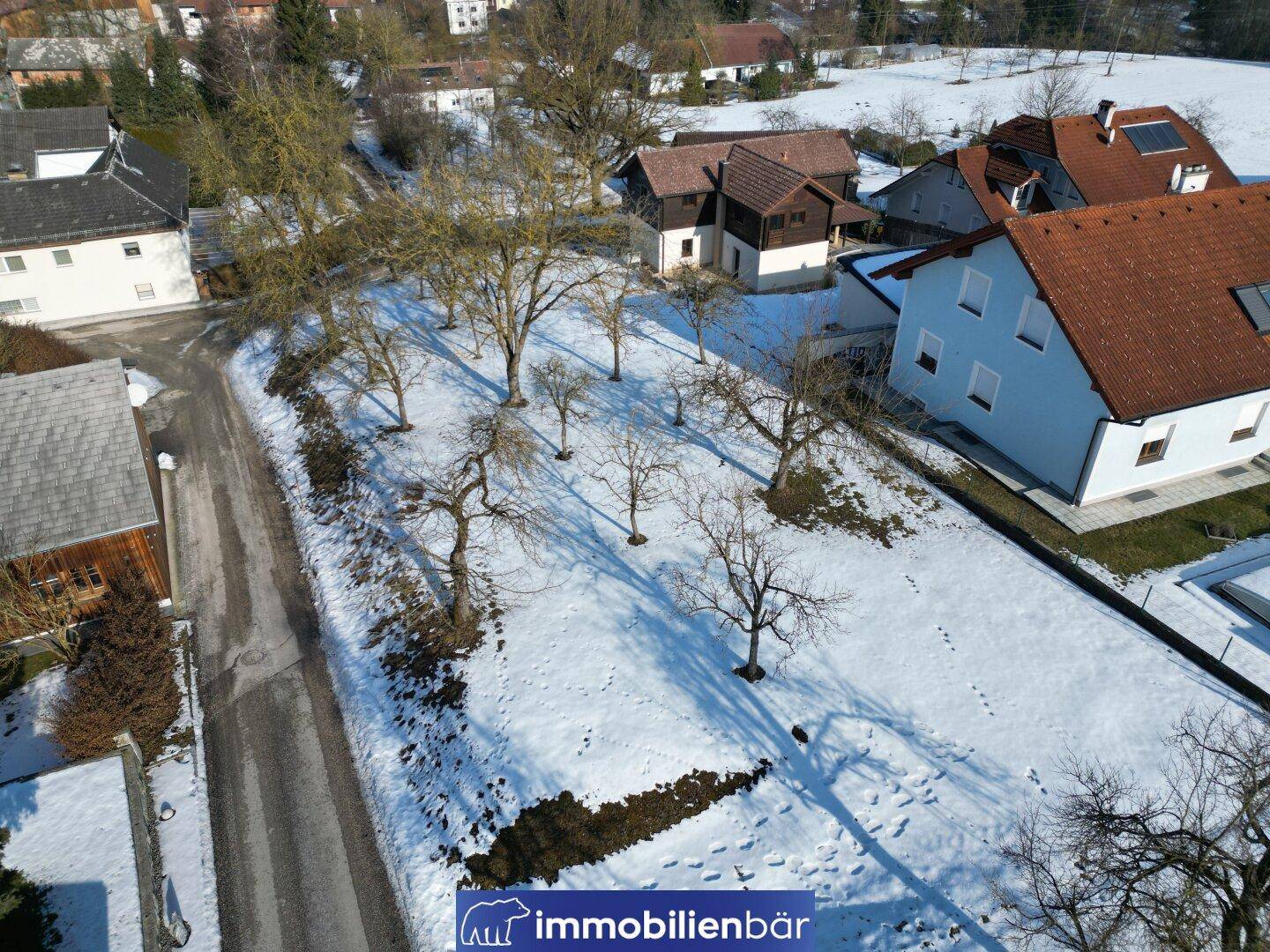 Luftaufnahme des Grundstücks im Winter, bedeckt mit Schnee und kahlen Bäumen.