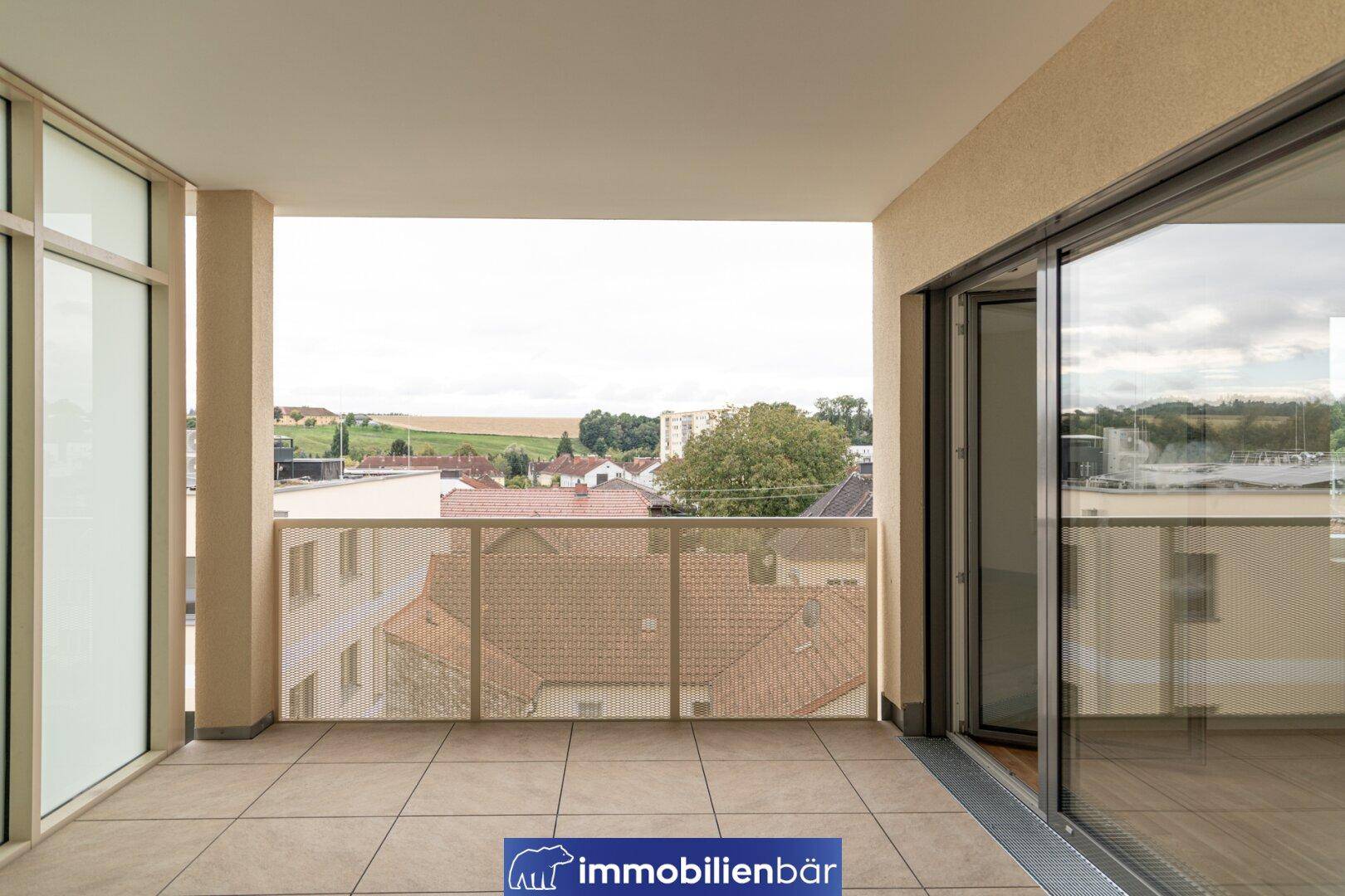 Großer Balkon mit weitem Blick über die Stadt und die grüne Landschaft.