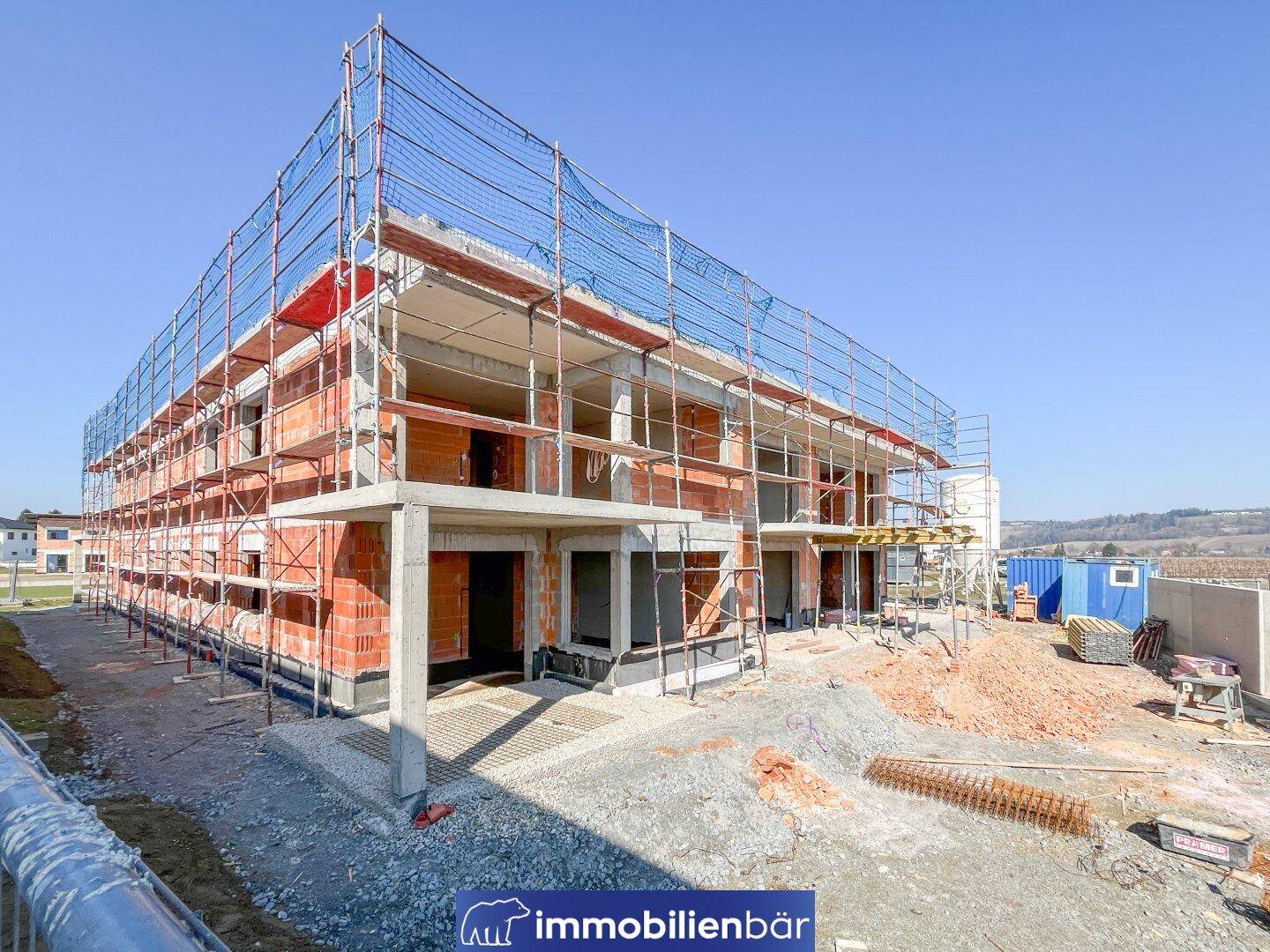 Großes Neubauprojekt im Rohbau mit Gerüst und vielen Wohneinheiten im Baufortschritt.