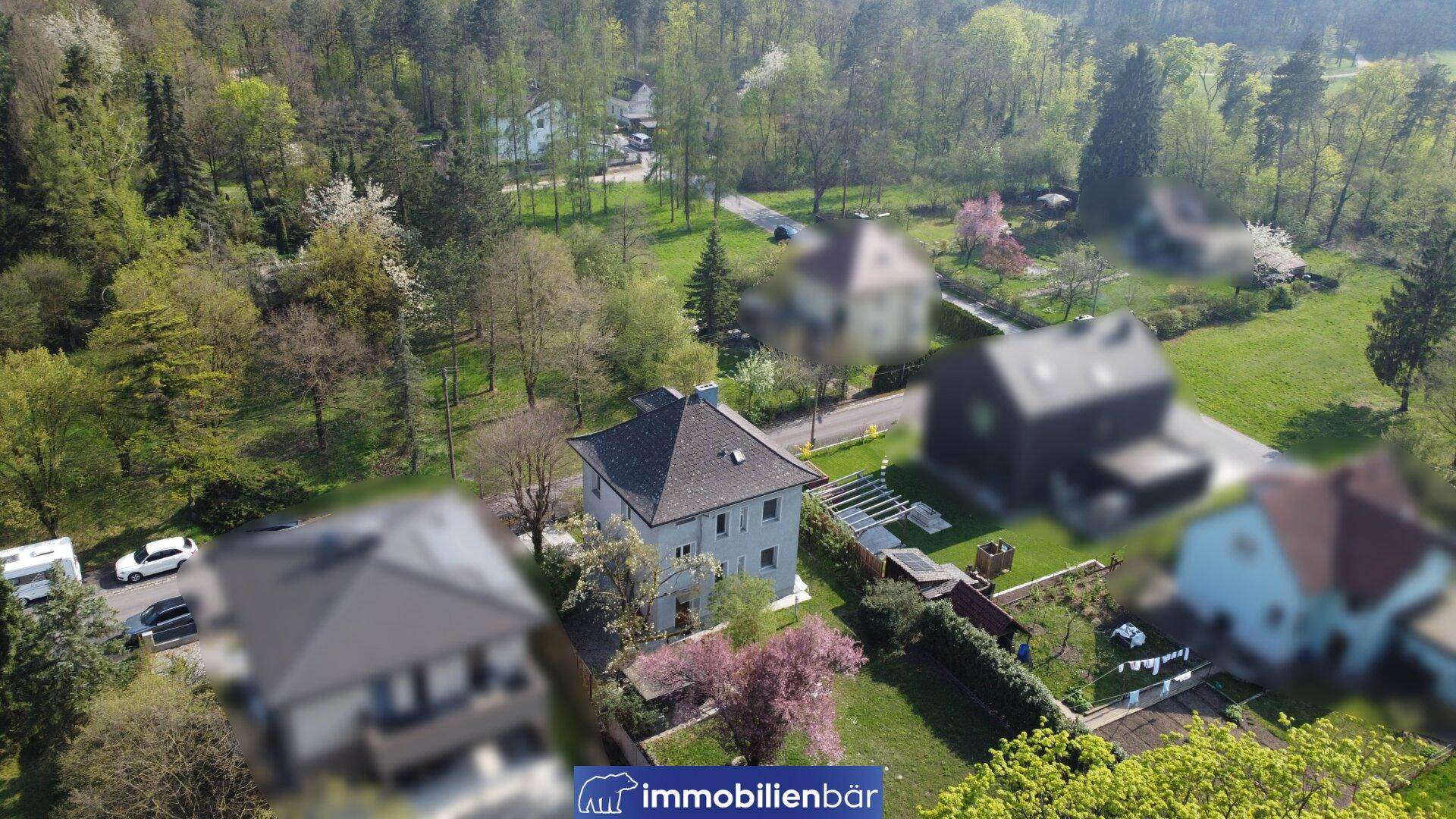 Weitläufige Luftaufnahme des Grundstücks und der grünen Umgebung mit anderen Gebäuden.