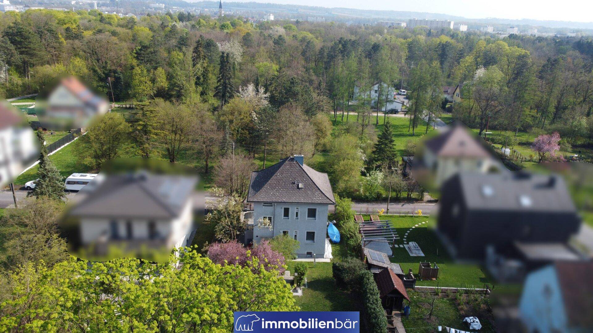 Luftaufnahme des Anwesens mit umliegender grüner Landschaft und weiteren Häusern.