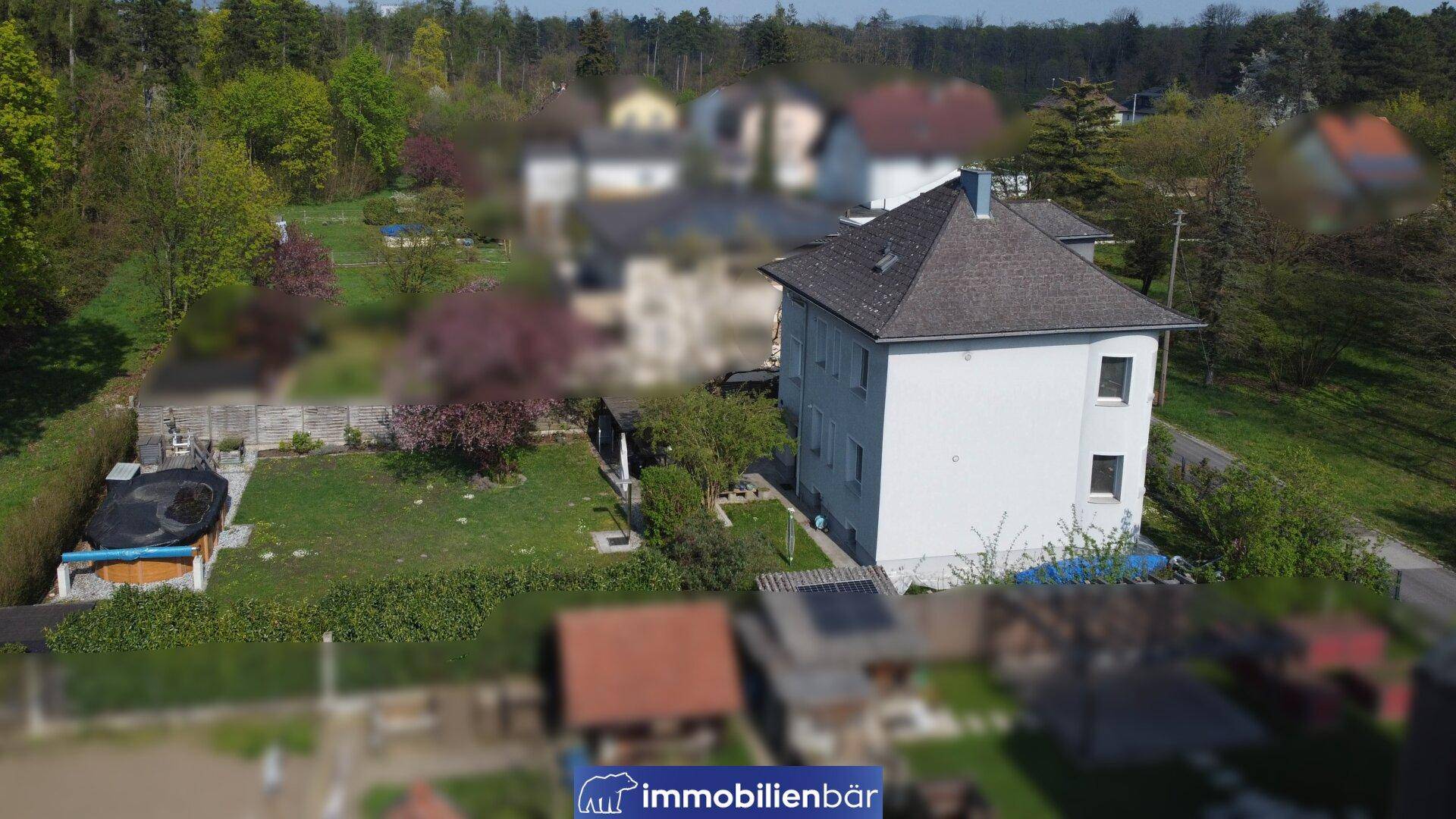 Luftaufnahme des Hauses und des Gartens mit einem Aufstellpool und viel Grün.