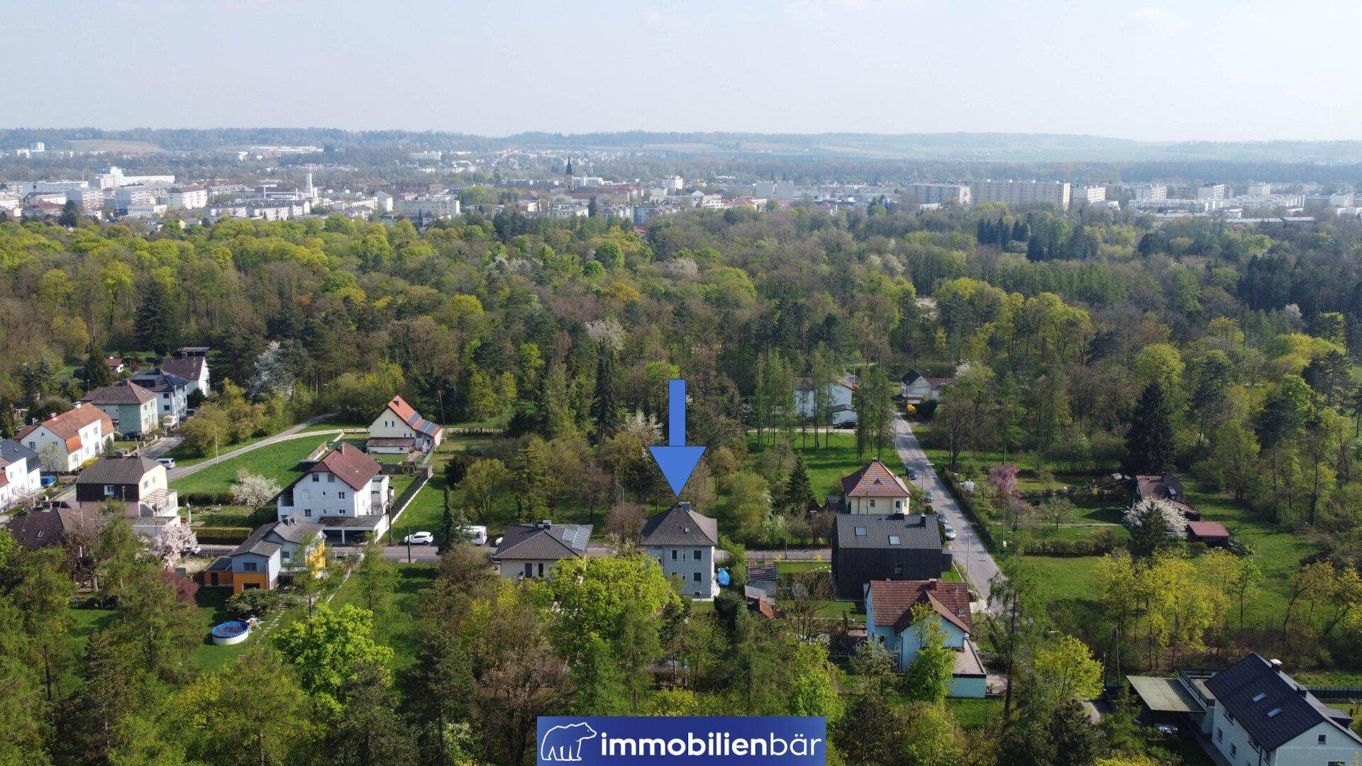 Übersichtliche Luftaufnahme des Hauses mit einem blauen Pfeil, der das Objekt markiert.