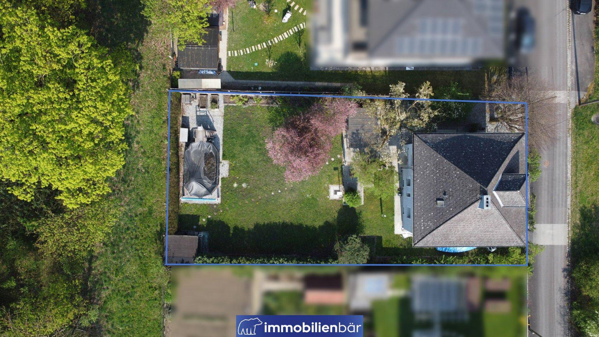 Draufsicht des Grundstücks mit blau umrandeter Parzelle, Haus und Gartenbereich.