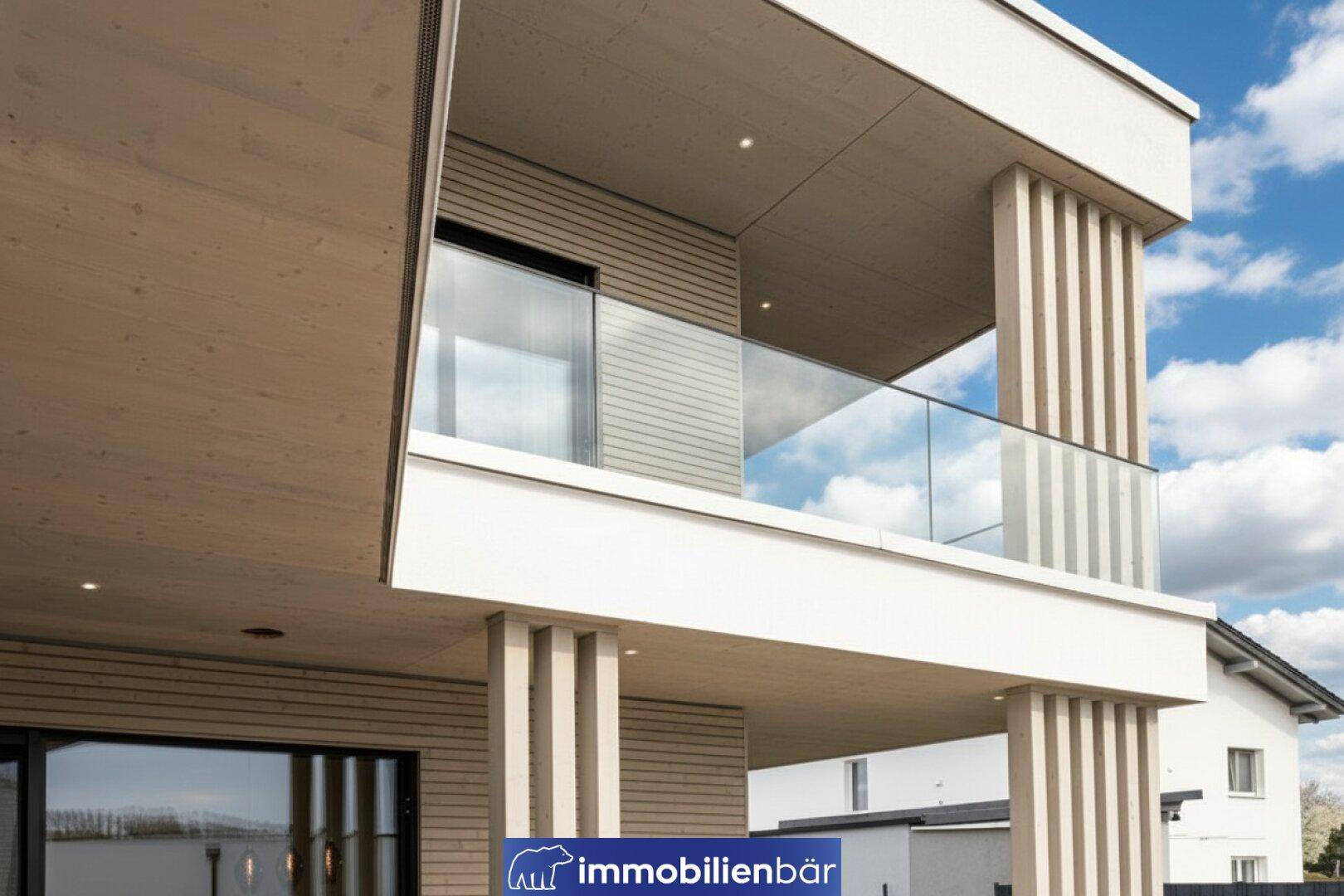 Detailansicht des modernen Balkons mit Glasgeländer und Holzverkleidung an der Fassade.