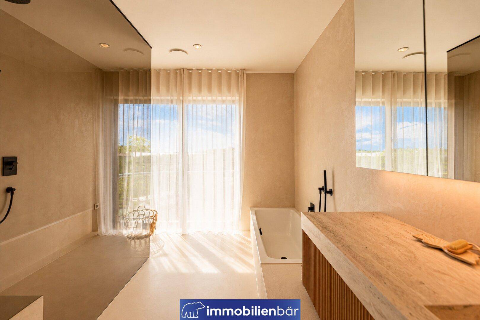 Modernes Badezimmer mit Badewanne, großem Fenster und stilvollem Holzwaschtisch.