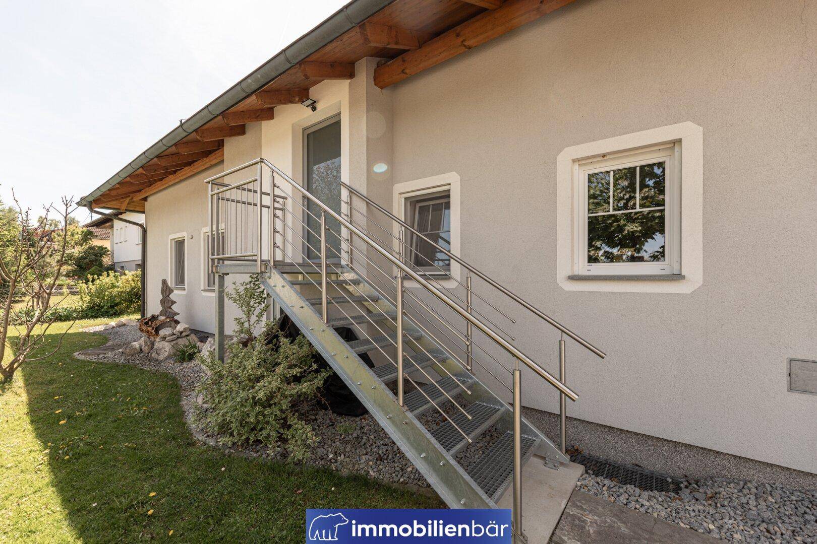 Außentreppe aus Metall führt zu einem oberen Eingang des modernen Hauses.