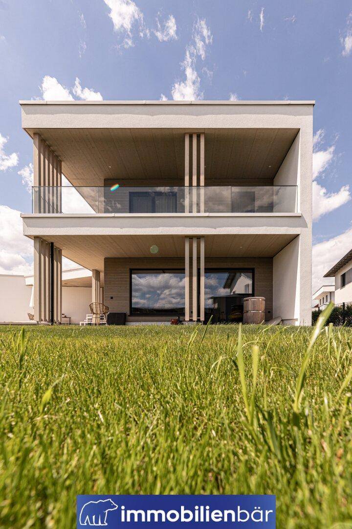 Direkte Rückansicht des modernen Hauses mit zwei Ebenen von Terrassen und Balkonen.
