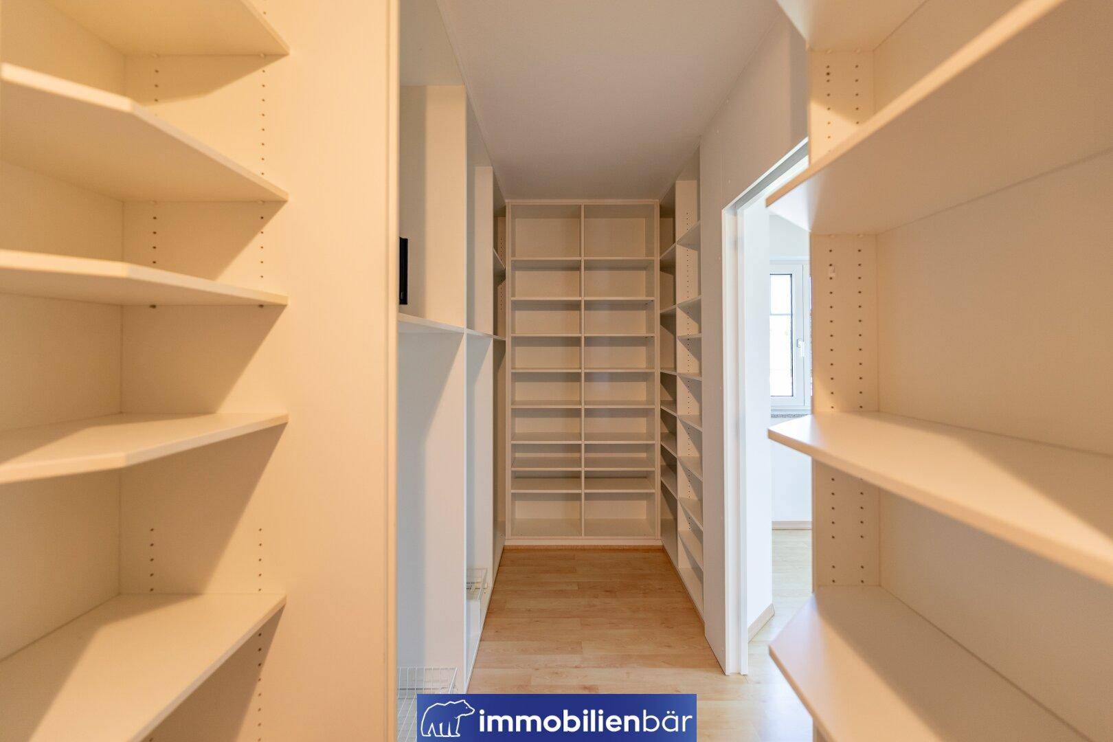 Geräumiger begehbarer Kleiderschrank mit vielen Regalen und Stauraum.