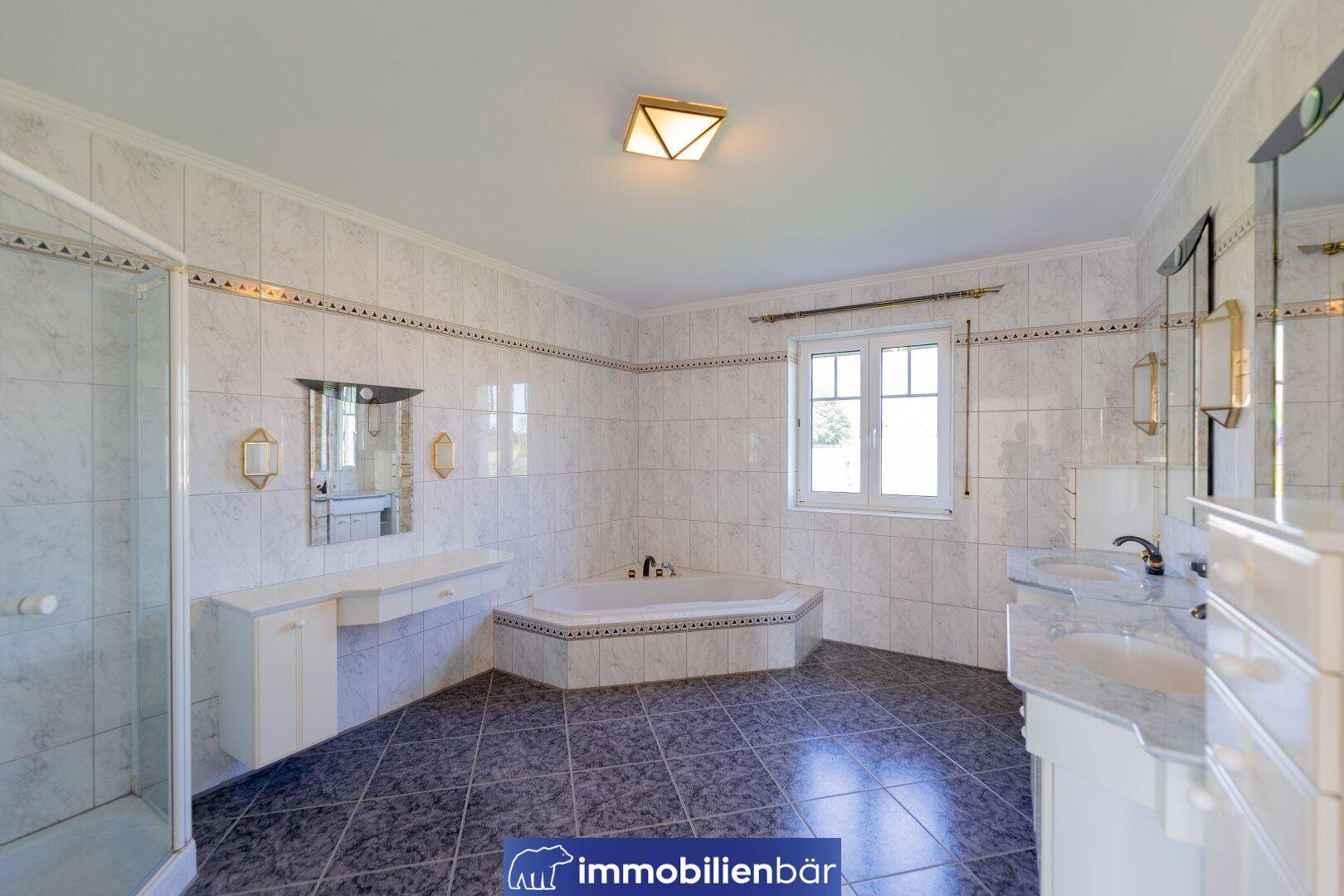 Geräumiges Badezimmer mit Eckbadewanne, Dusche und Fenster für Tageslicht.