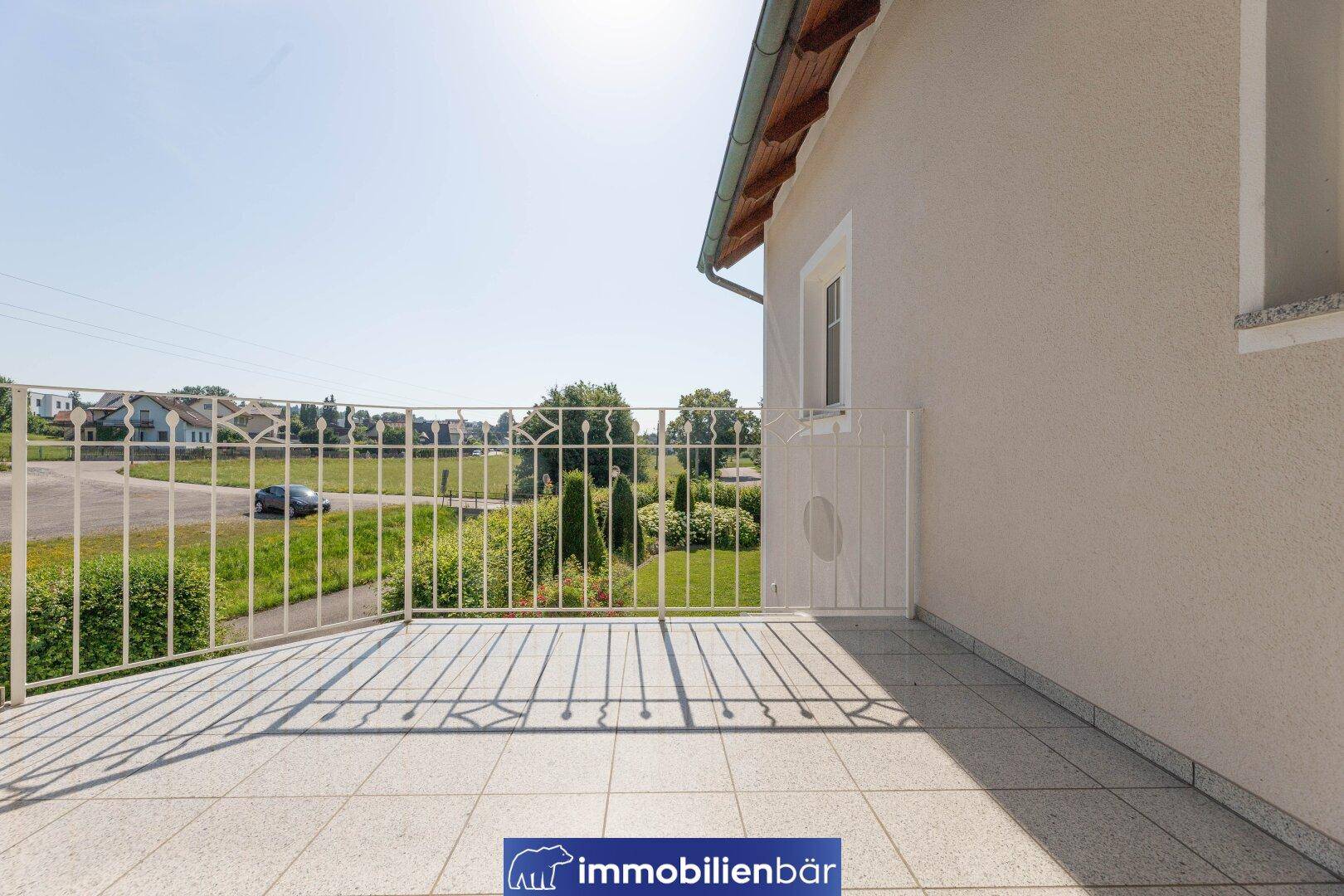 Geräumiger Balkon mit Fliesenboden und schmiedeeisernem Geländer, bietet weite Aussicht.