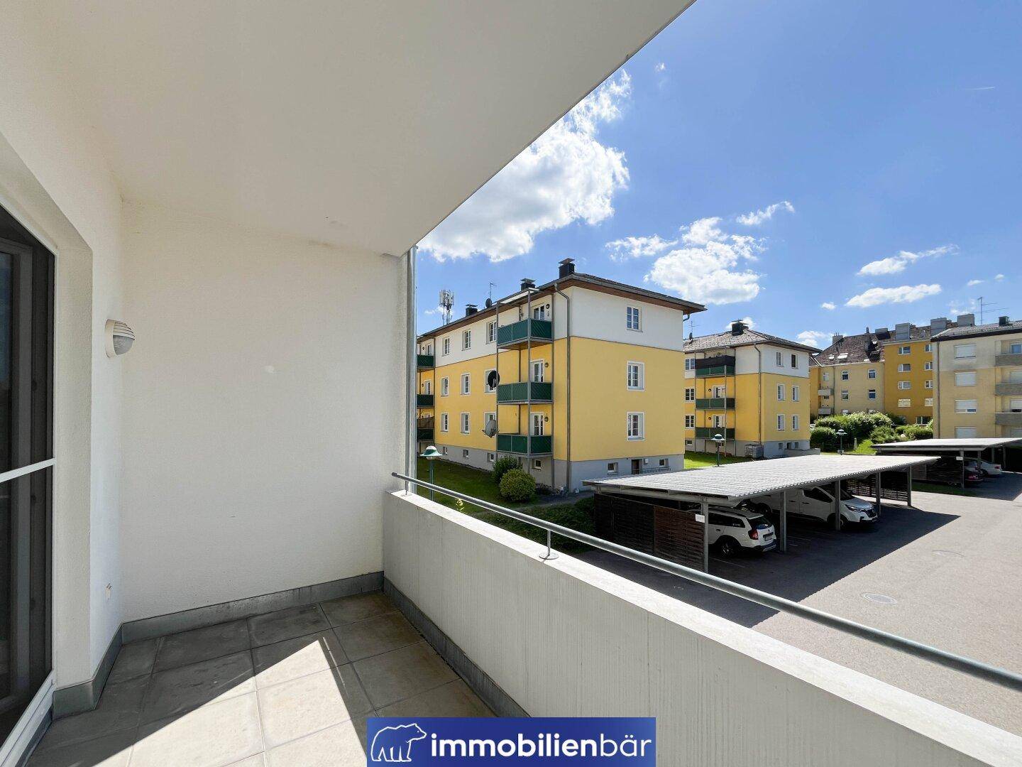 Balkon mit Blick auf die umliegenden Wohngebäude und die Carport-Anlagen der Wohnsiedlung.