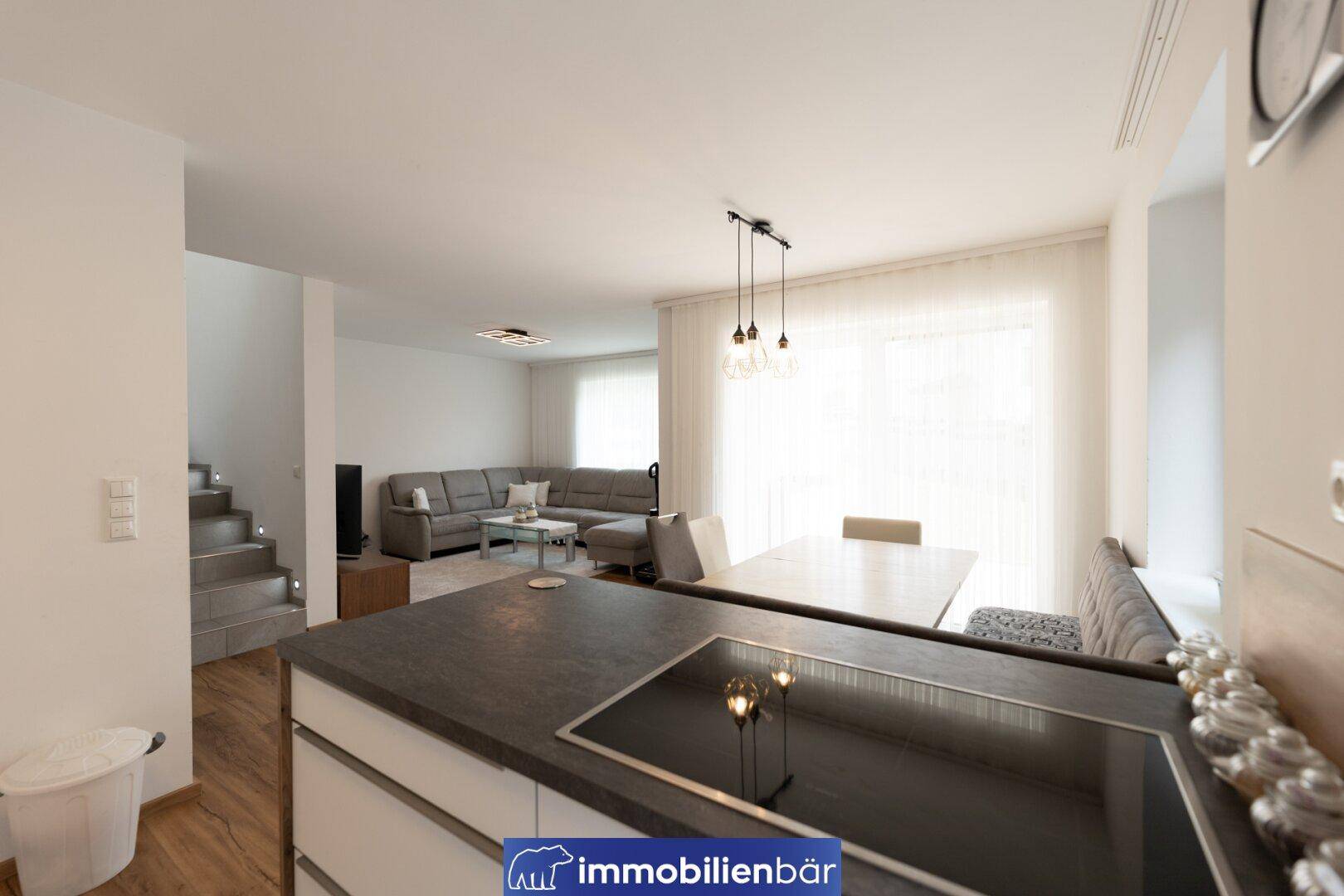 Offener Wohnbereich mit integrierter Küche, Essplatz und Blick auf das Wohnzimmer.
