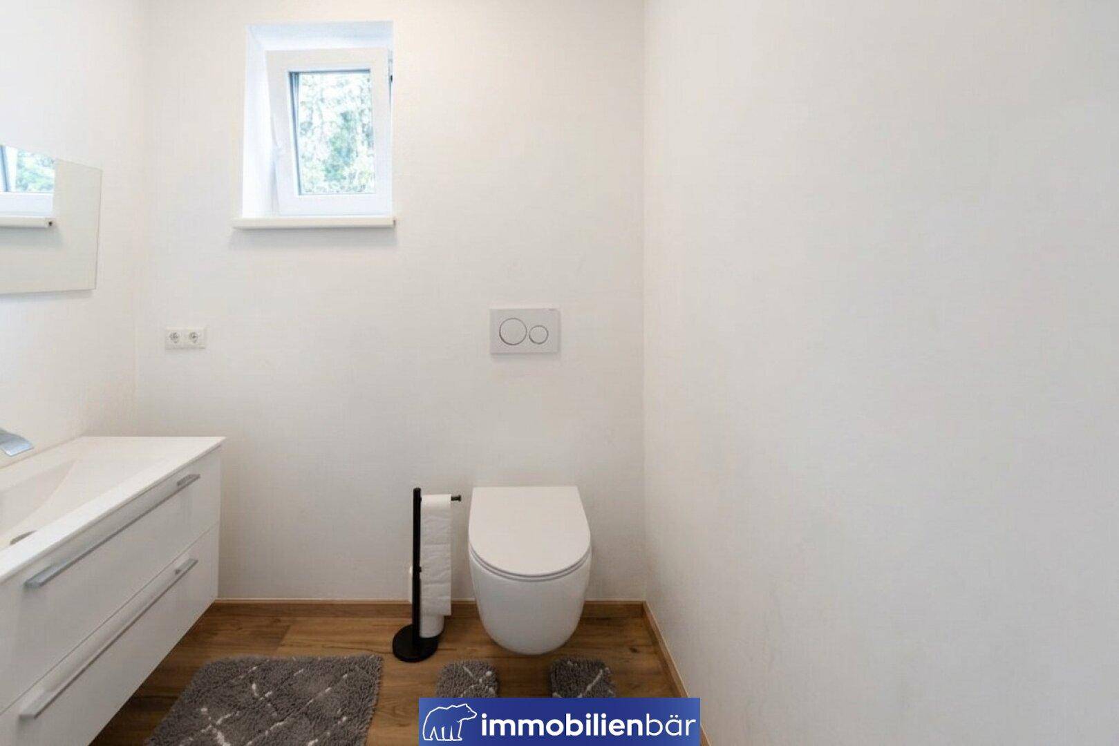 Modernes Gäste-WC mit wandhängendem WC, kleinem Waschbecken und Fenster.
